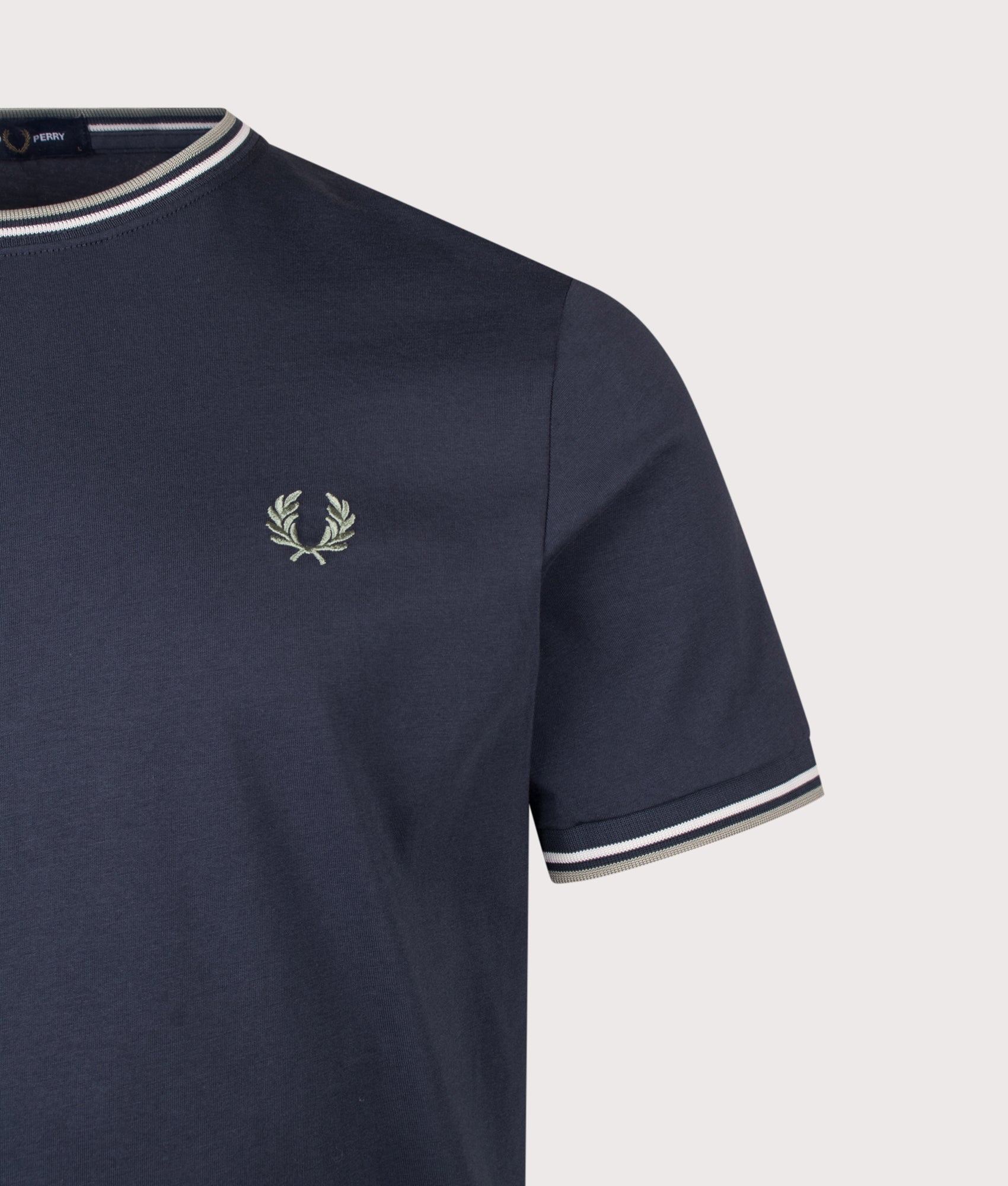 Fred Perry Regular Fit Twin Tipped T-Shirt in Dark Airforce, Ecru and Seagrass at EQVVS Menswear. Detail shot.