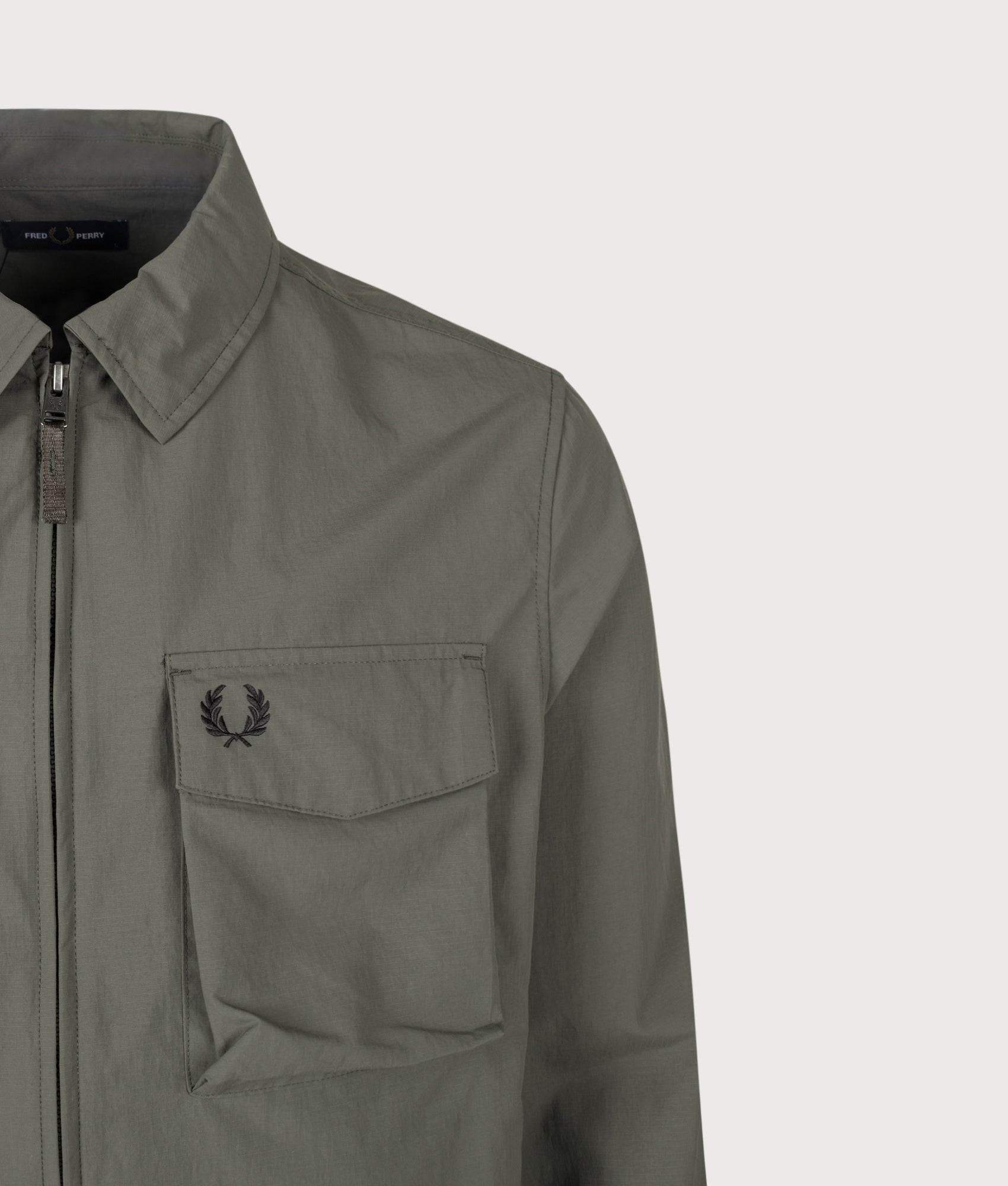 Fred Perry Ripstop Pocket Overshirt in Field Green at EQVVS Menswear. Detail shot.