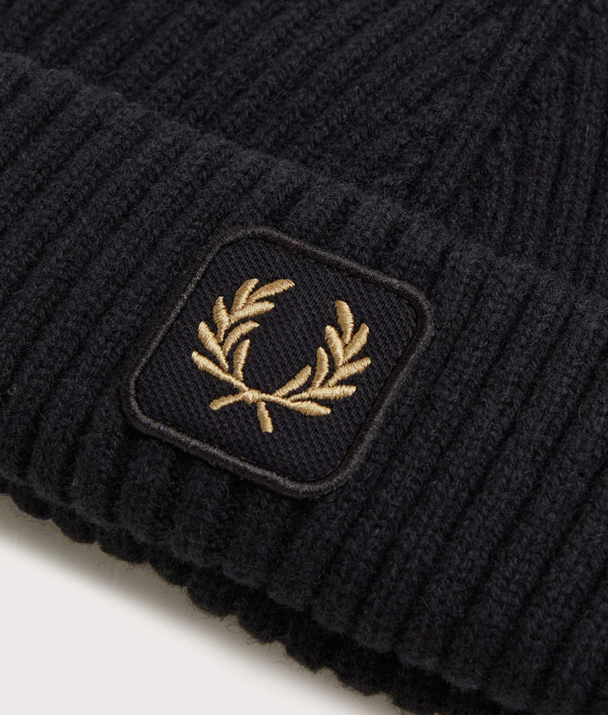 Fred Perry Ribbed Wool Beanie in Black at EQVVS Menswear. Detail shot.
