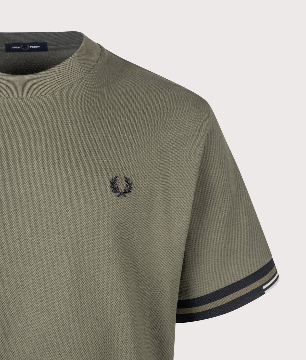 Fred Perry Relaxed Fit Tipped Cuff Piqué T-Shirt in Laurel Wreath Green at EQVVS Menswear. Detail shot.