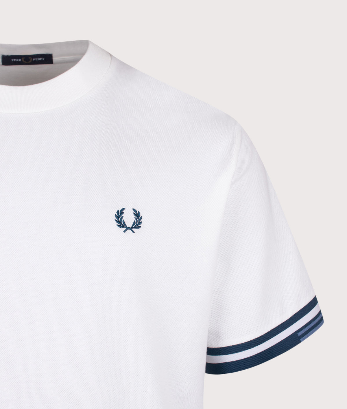 Fred Perry release the Relaxed Fit Tipped Cuff Pique T-Shirt in White at EQVVS Menswear.
