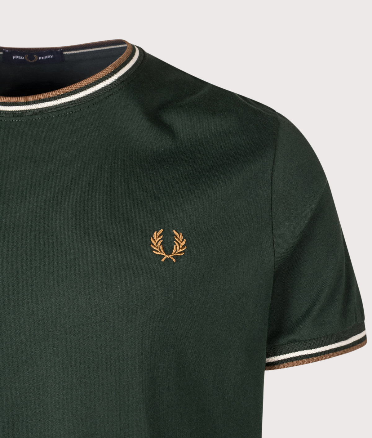 Fred Perry Twin Tipped T-Shirt in Grassroots, Ecru and Bronze at EQVVS Menswear. Detail shot.