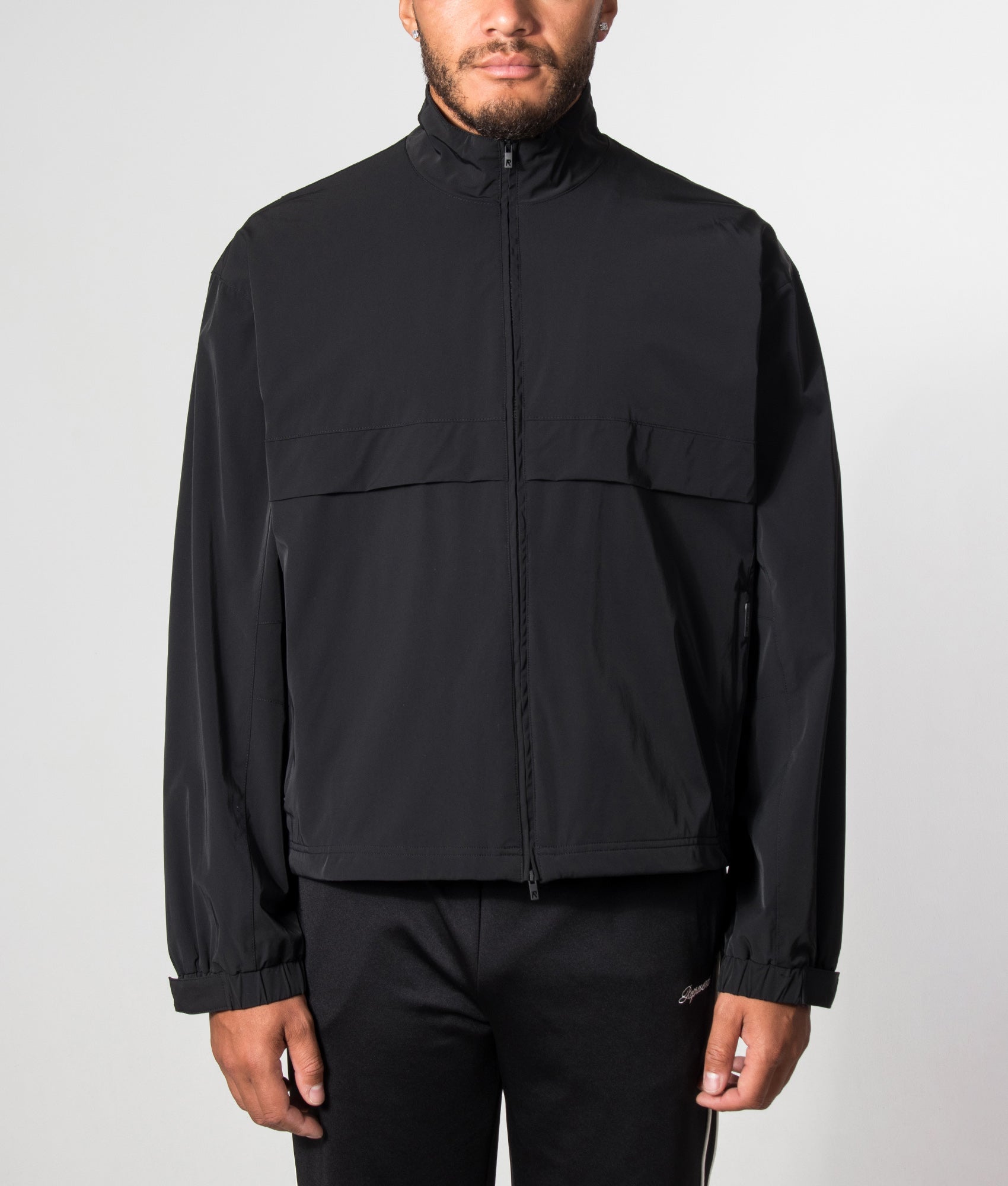 Represent Oversized Initial Nylon Track Jacket in Jet Black at EQVVS Menswear. Model front shot.