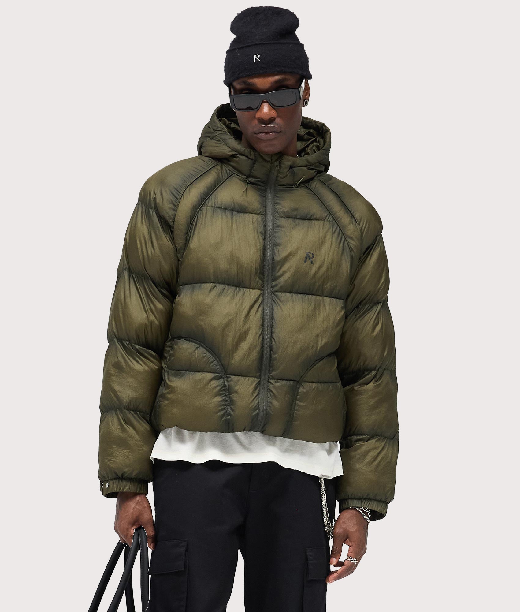 Represent Translucent Hooded Puffer Coat in Washed Olive at EQVVS Menswear. Front shot.