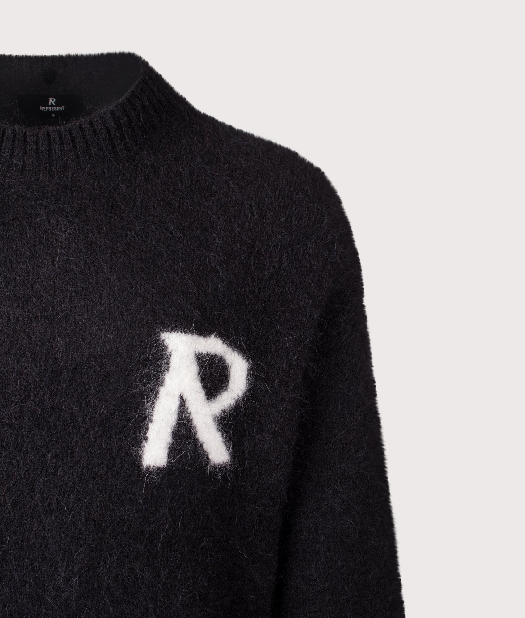 REPRESENT Logo Knit Sweatshirt in Jet Black at EQVVS Menswear. Detail shot.