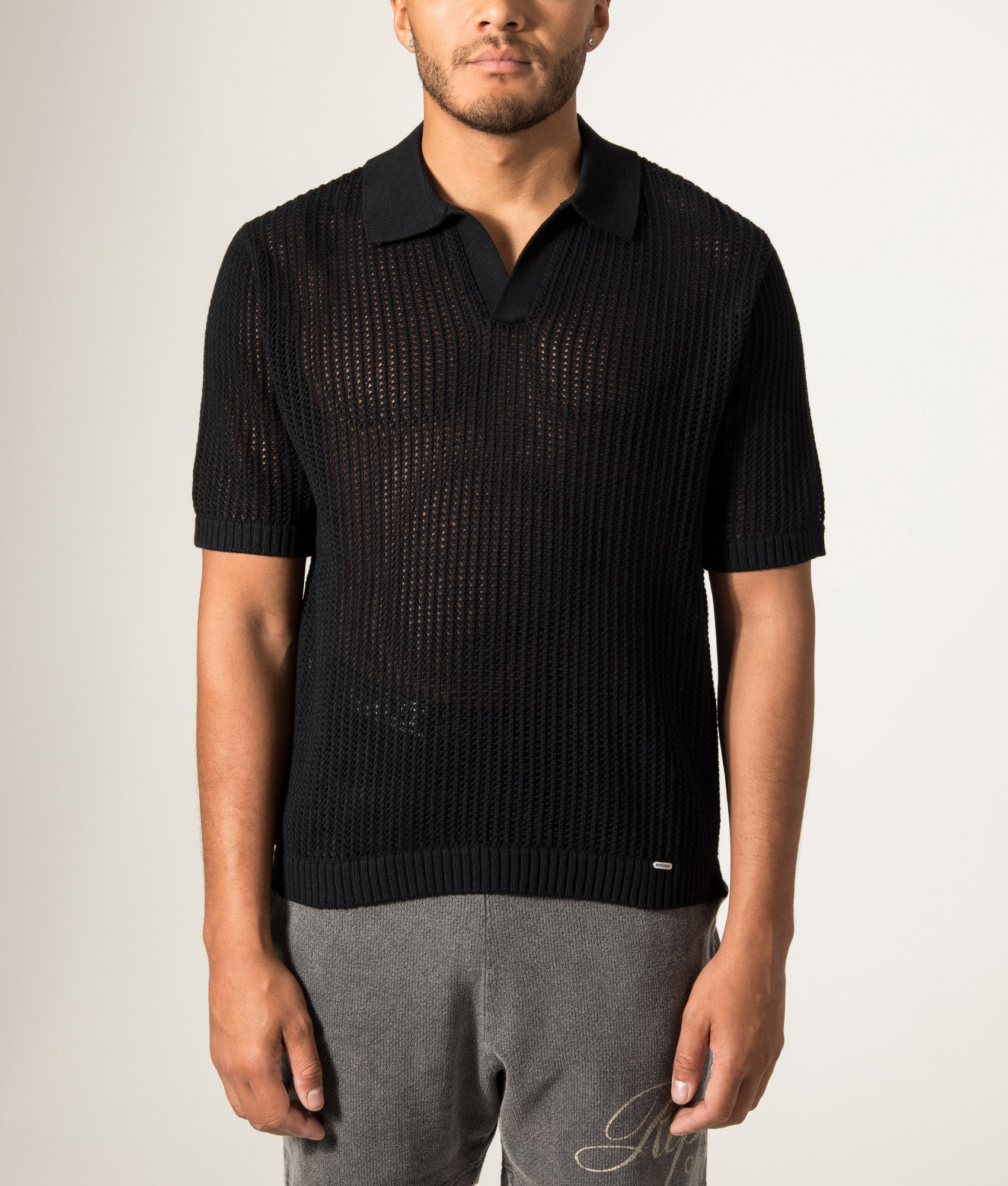 REPRESENT Beverly Open Gauge Knitted Polo Shirt in Jet Black at EQVVS Menswear. Model front shot.