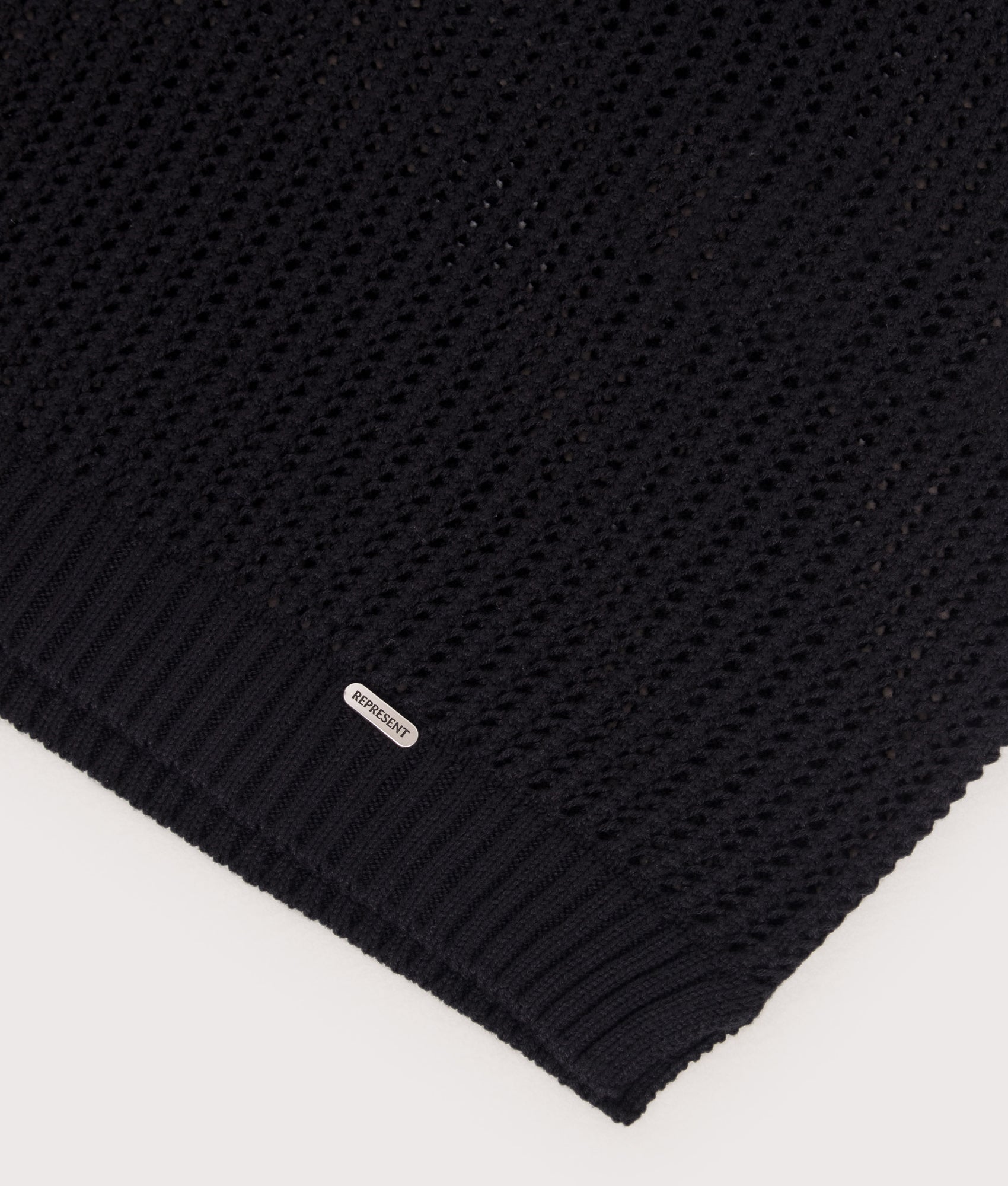 REPRESENT Beverly Open Gauge Knitted Polo Shirt in Jet Black at EQVVS Menswear. Detail shot.
