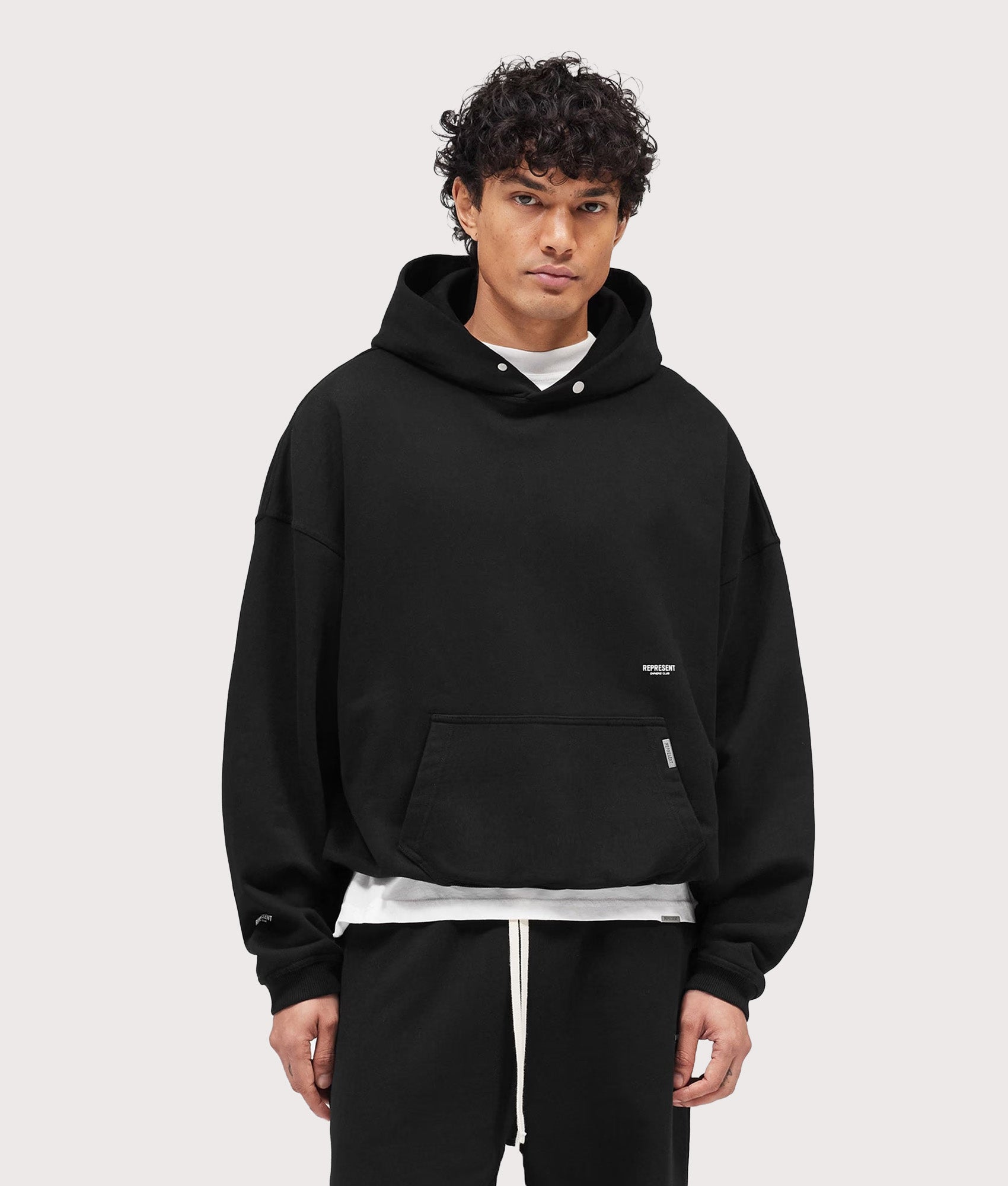 Represent Oversized Micro Owners Club Hoodie in Jet Black at EQVVS Menswear. Model front shot.