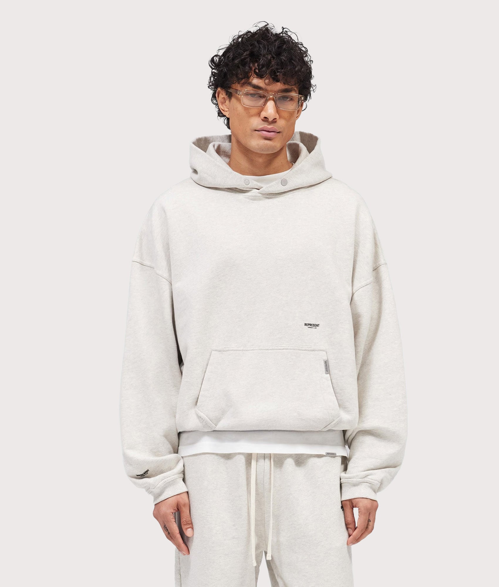 Represent Oversized Micro Owners Club Hoodie in Cream Marl at EQVVS Menswear. Front shot.