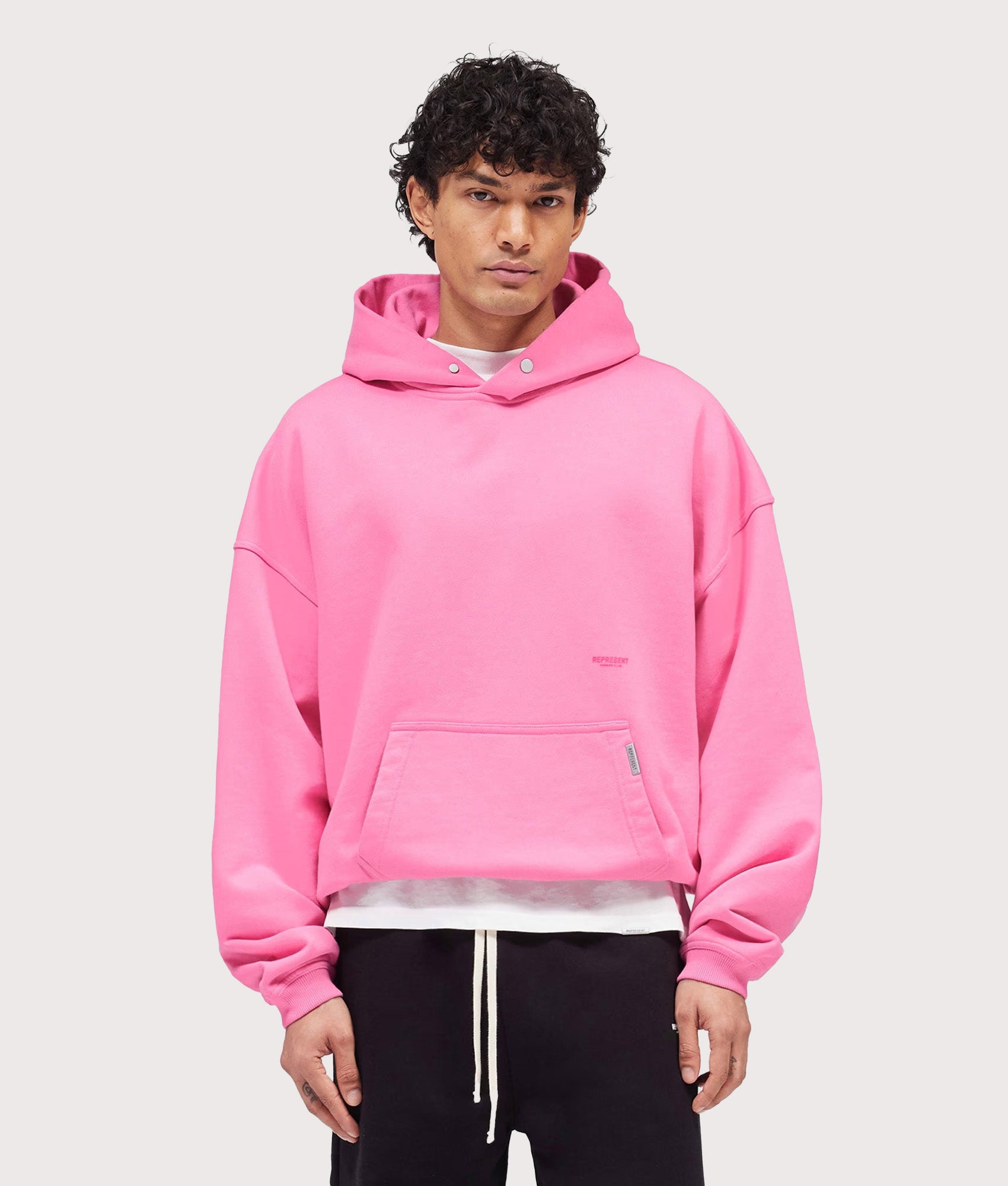Represent Oversized Micro Owners Club Hoodie in Pink at EQVVS Menswear. Model front shot.