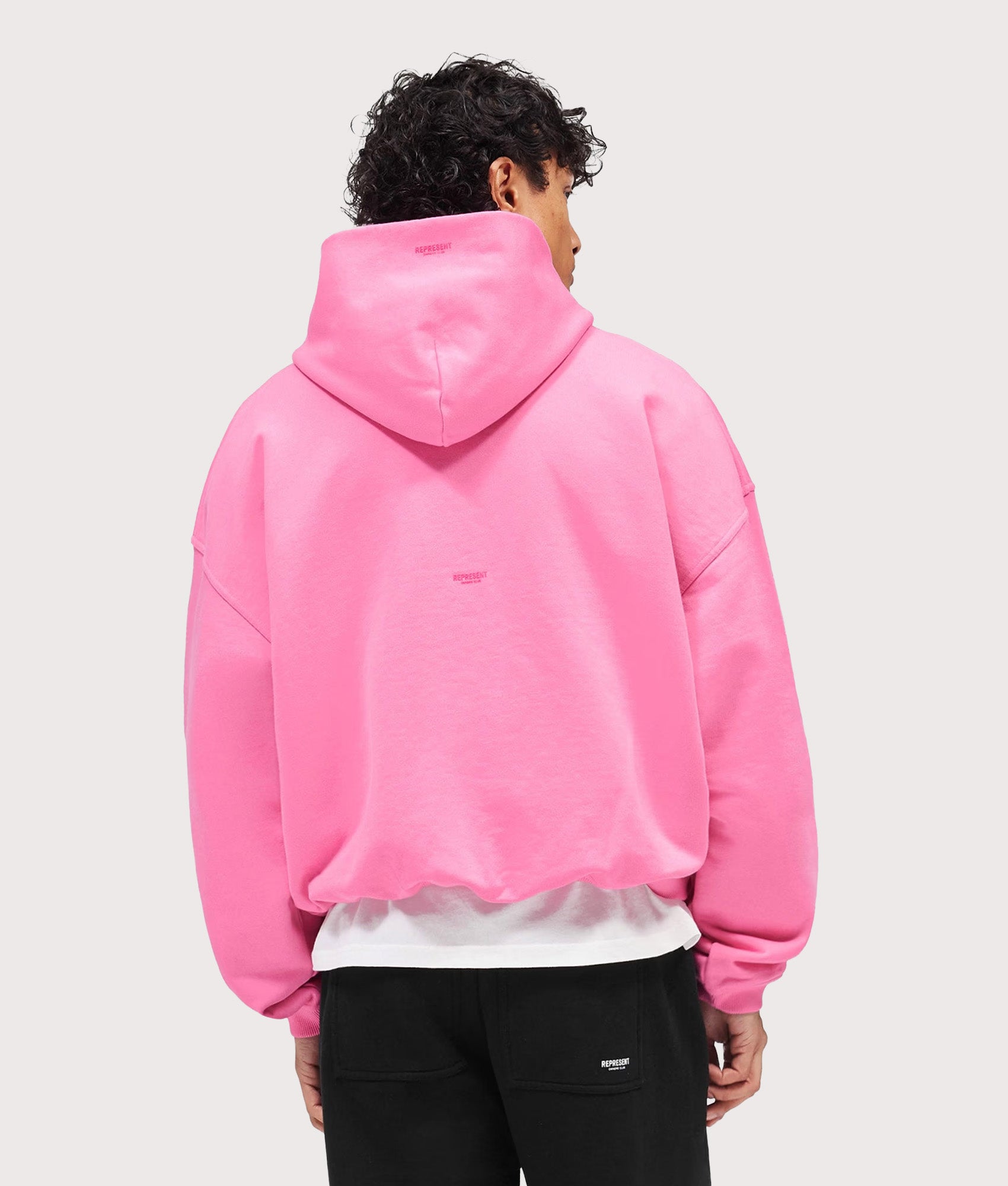 Represent Oversized Micro Owners Club Hoodie in Pink at EQVVS Menswear. Model back shot.