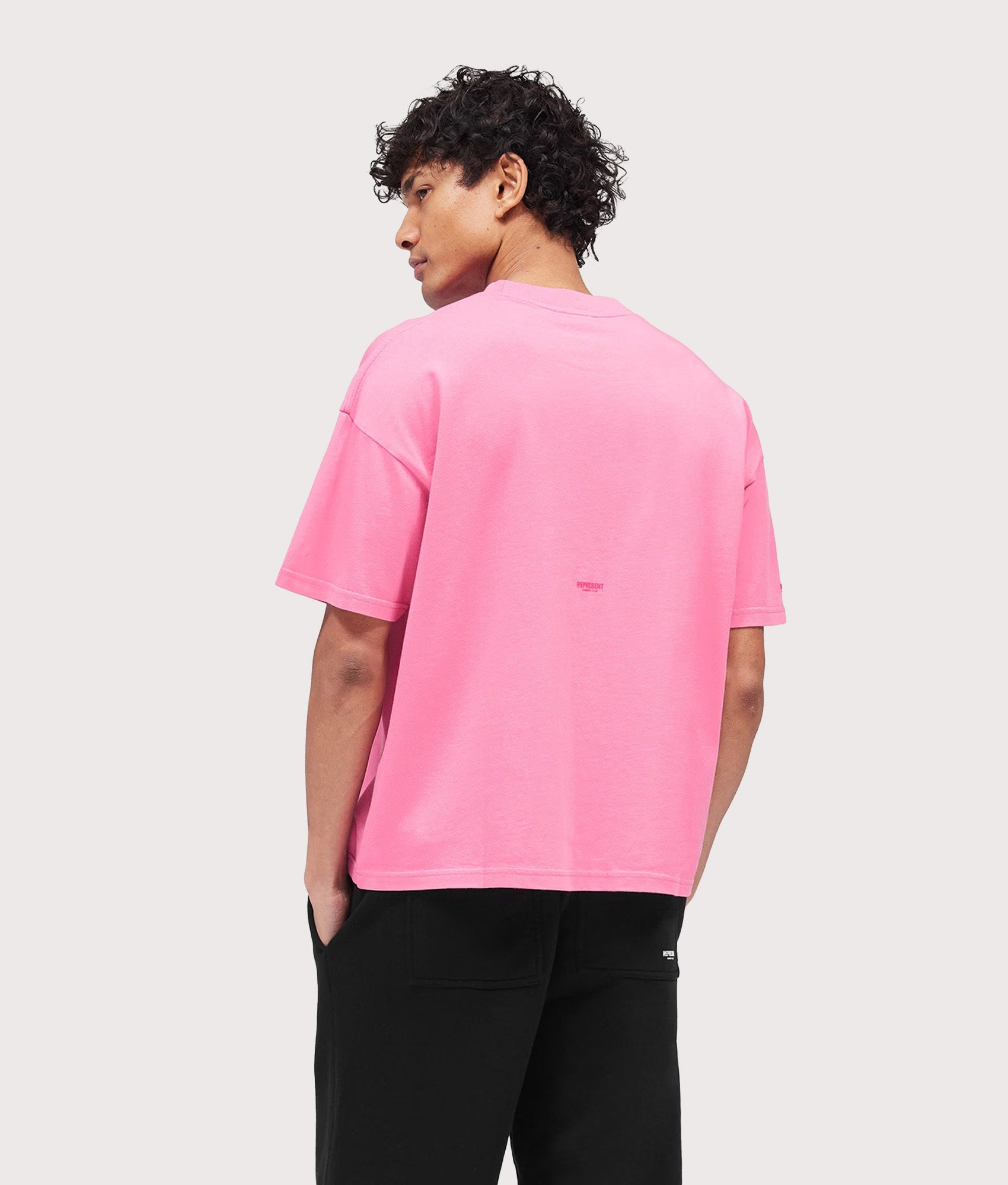 Represent Oversized Micro Owners Club T-Shirt in Pink at EQVVS Menswear. Model back shot.