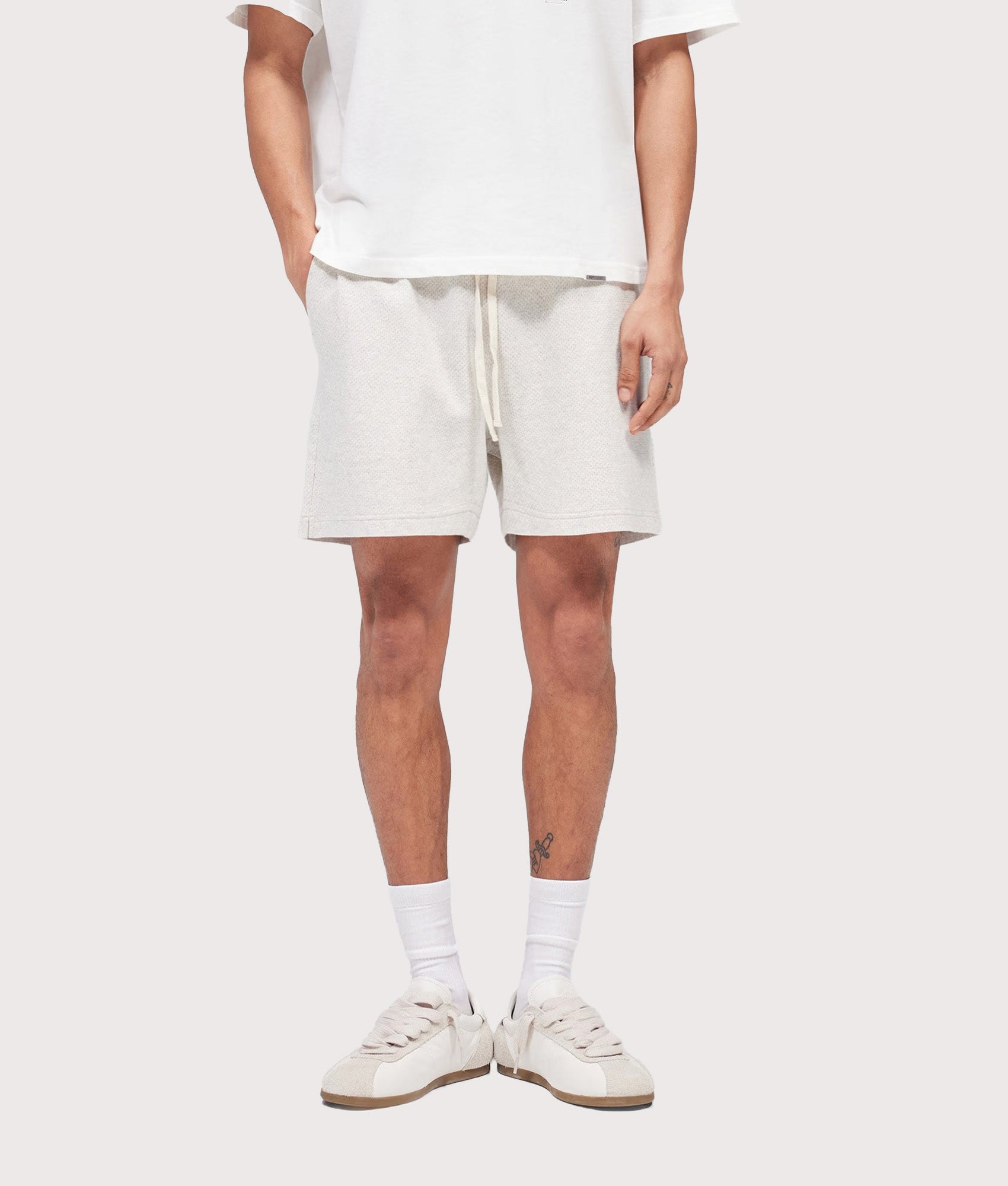 Represent Relaxed fit Micro Owners Club Shorts in Cream Marl at EQVVS Menswear. Model front shot.