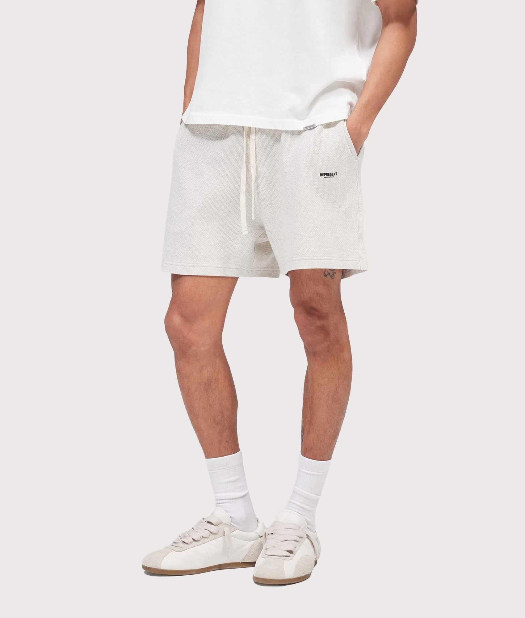 Represent Relaxed fit Micro Owners Club Shorts in Cream Marl at EQVVS Menswear. Angled model front shot.