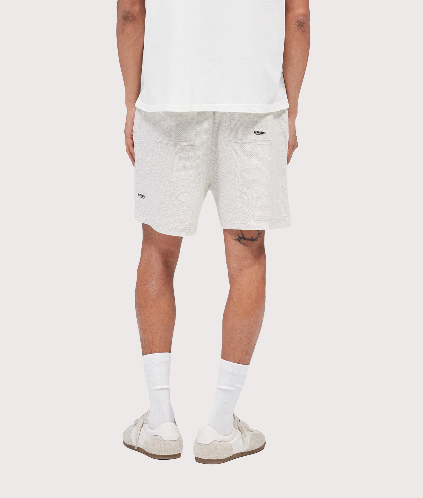 Represent Relaxed fit Micro Owners Club Shorts in Cream Marl at EQVVS Menswear. Model back shot.