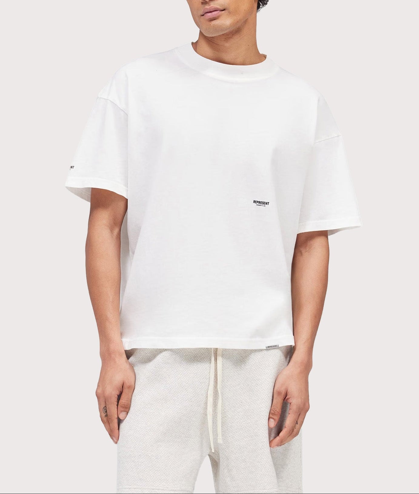Represent Oversized Micro Owners Club T-Shirt in Flat White at EQVVS Menswear. Model front shot.
