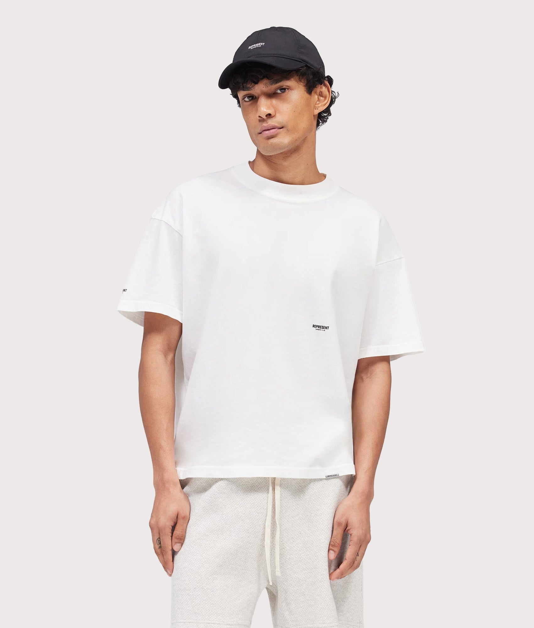 Represent Oversized Micro Owners Club T-Shirt in Flat White at EQVVS Menswear. Model front shot.