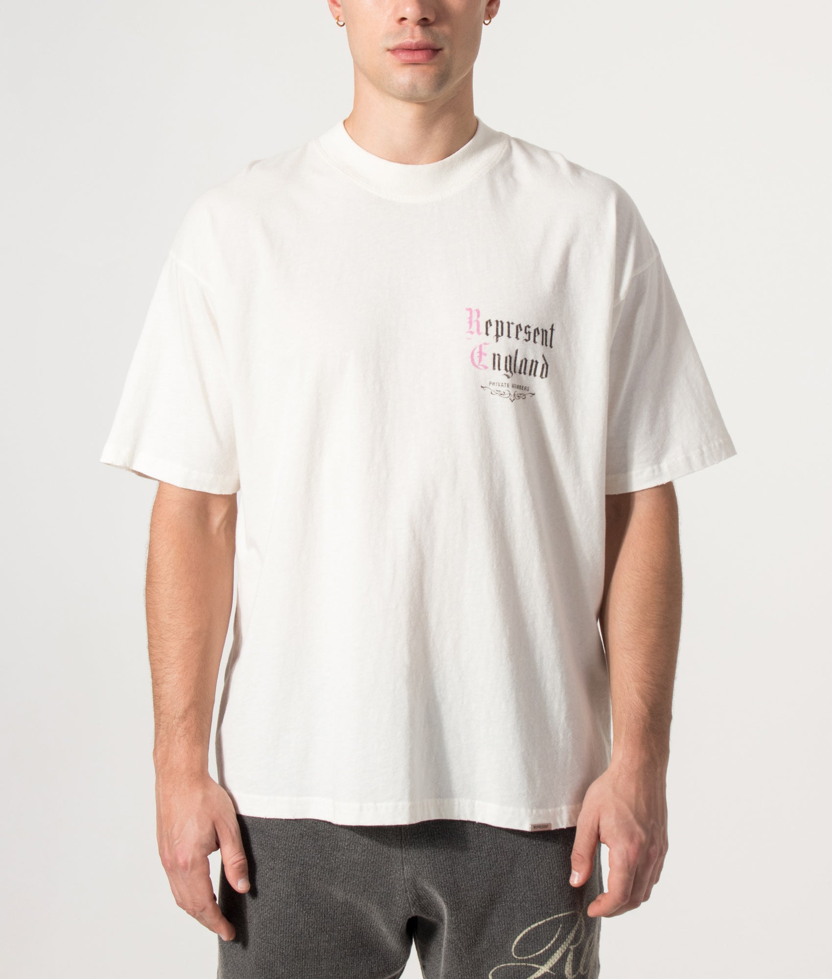 Represent Oversized Fit Private Members T-Shirt in Flat White at EQVVS Menswear. Model front shot.