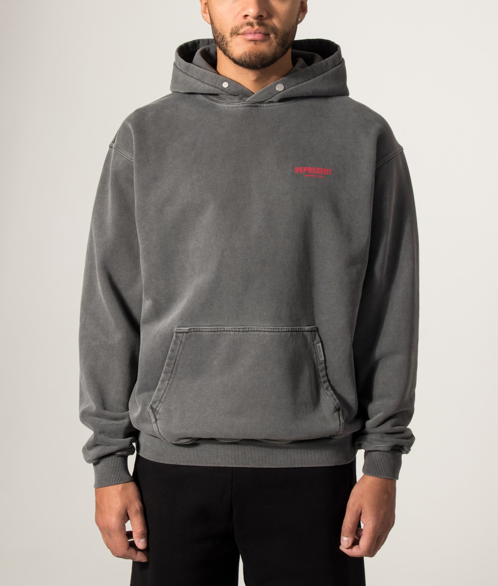 Represent Oversized Fit Represent Owners Club Hoodie in Washed Black at EQVVS Menswear. Model front shot.