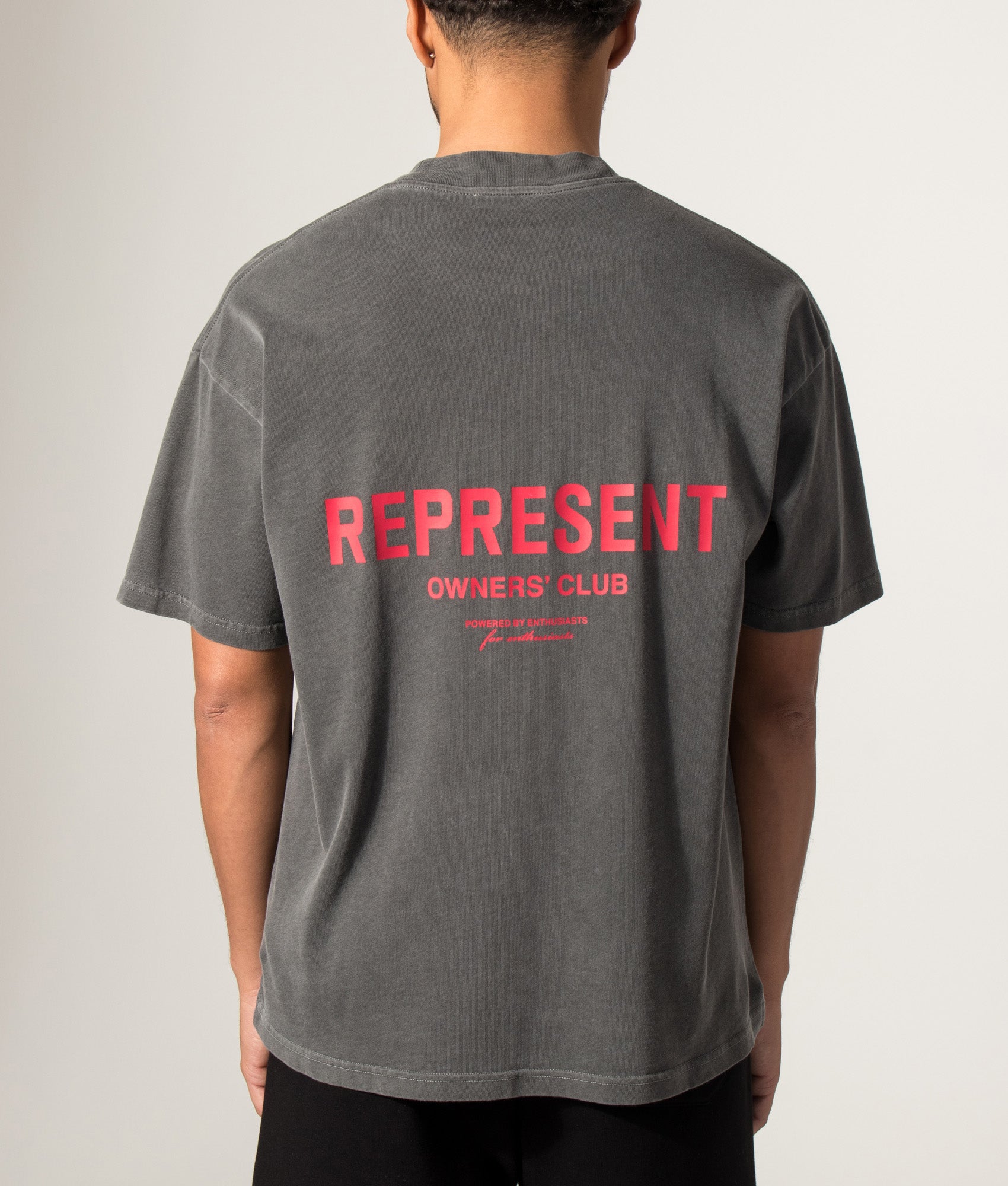 Represent Oversized Fit Represent Owners Club T-Shirt in Washed Black at EQVVS Menswear. Model back shot.