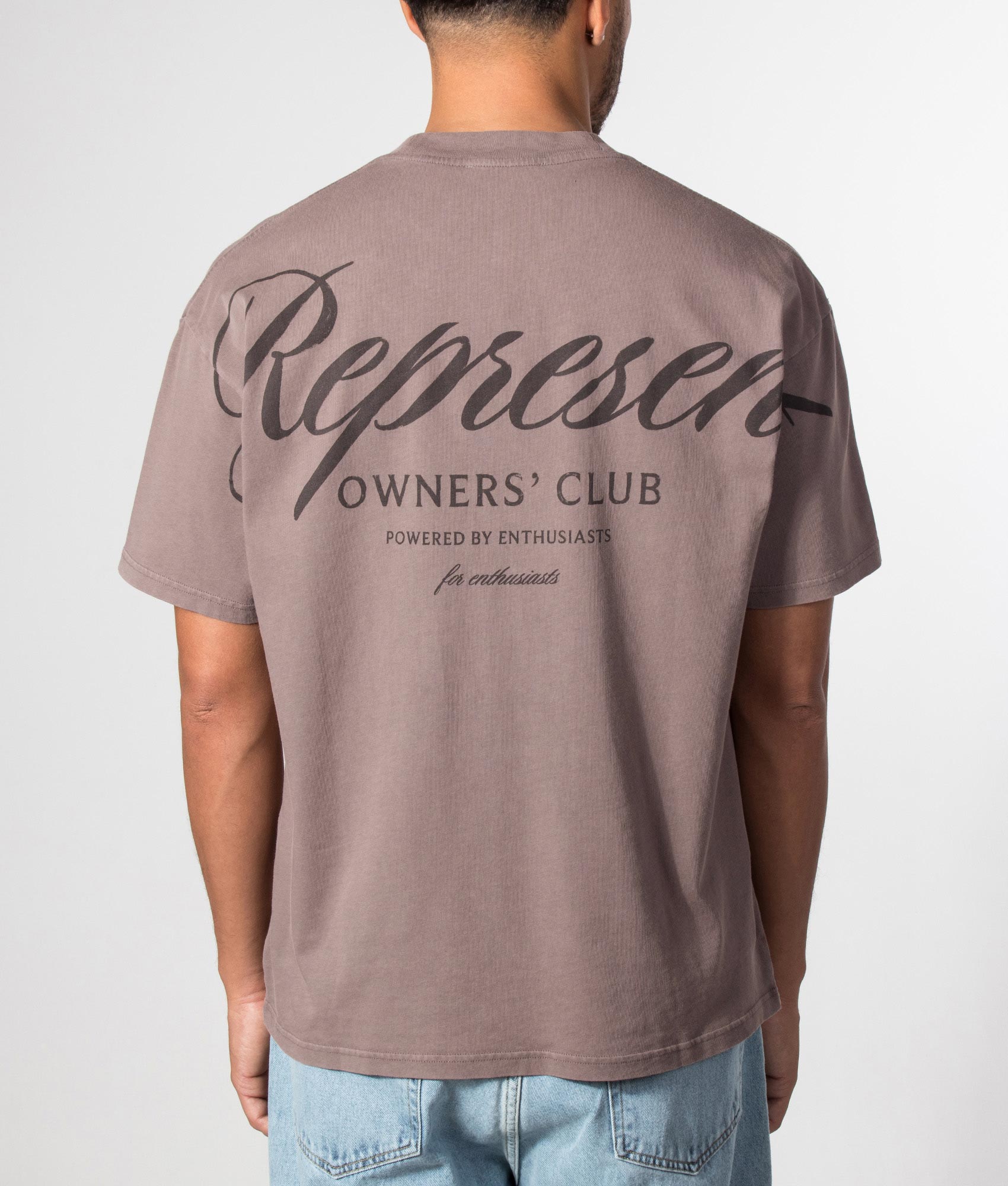Represent Oversized Fit Represent Owners Club Script T-Shirt in Truffle at EQVVS Menswear. Model back shot.