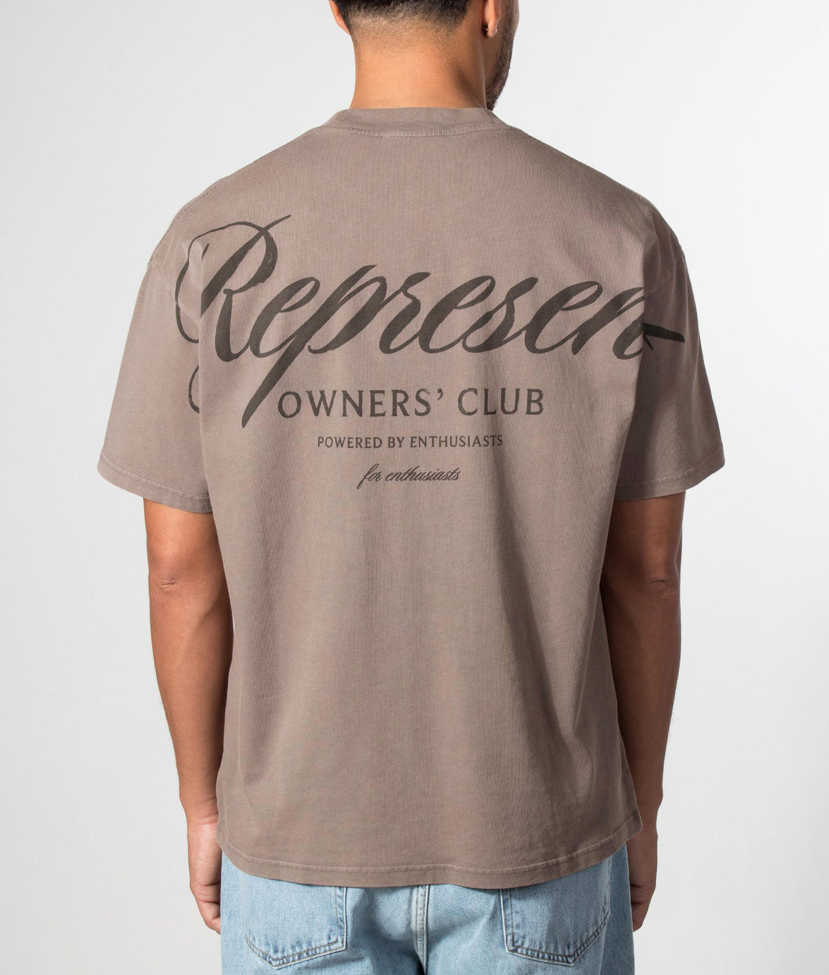 Represent Oversized Fit Represent Owners Club Script T-Shirt in Truffle at EQVVS Menswear. Model back shot.