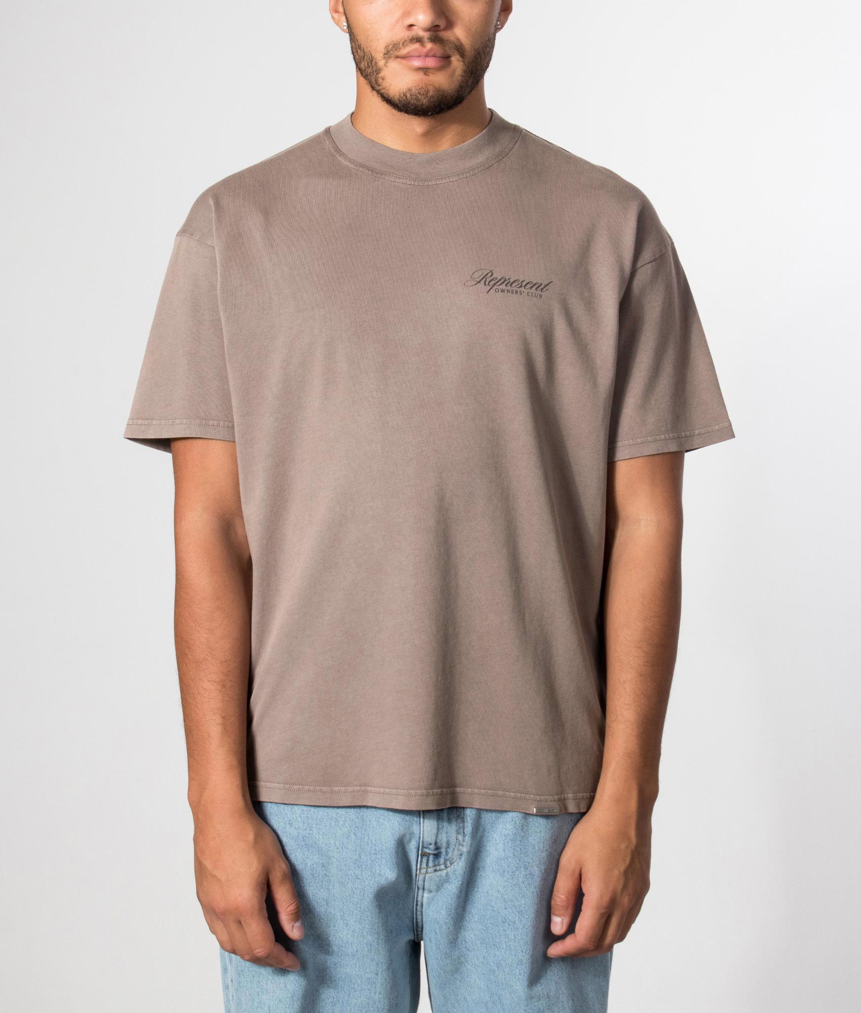 Represent Oversized Fit Represent Owners Club Script T-Shirt in Truffle at EQVVS Menswear. Model front shot.