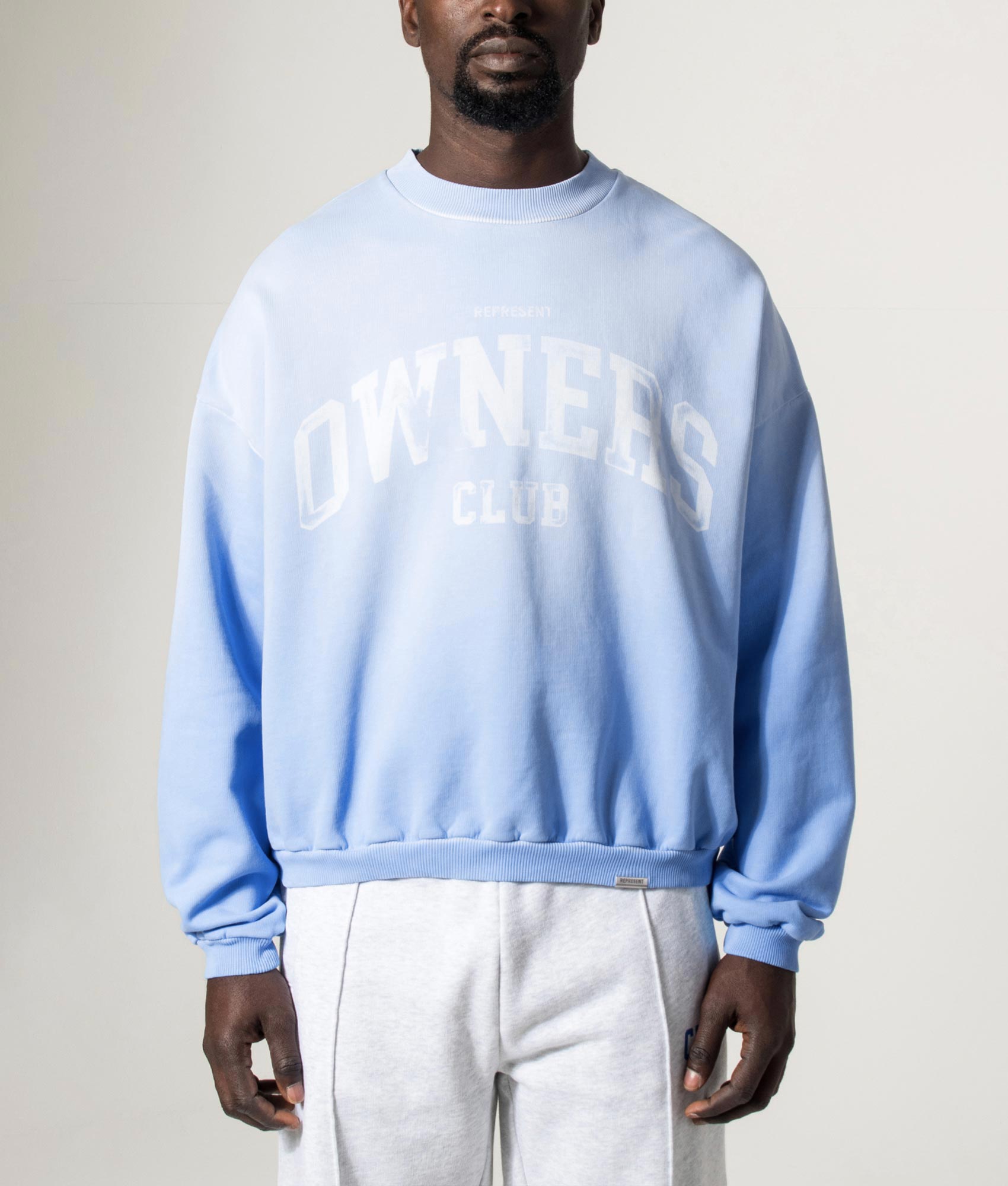 REPRESENT Oversized 2.0 Owners Club Sweatshirt in Sky Blue at EQVVS Menswear. Model front shot.
