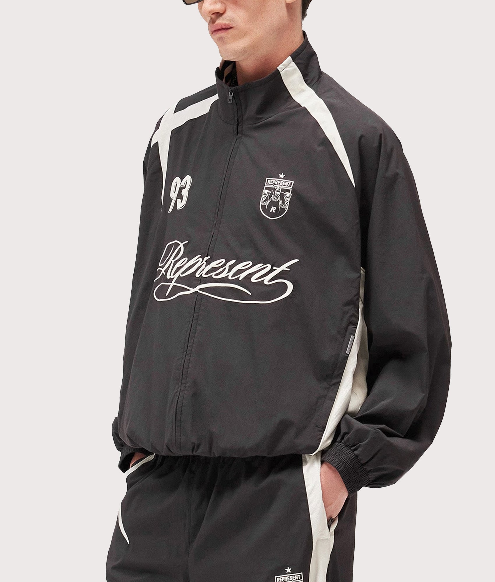 Represent Woven Track Star Jacket in Jet Black at EQVVS Menswear. Model angled front shot.