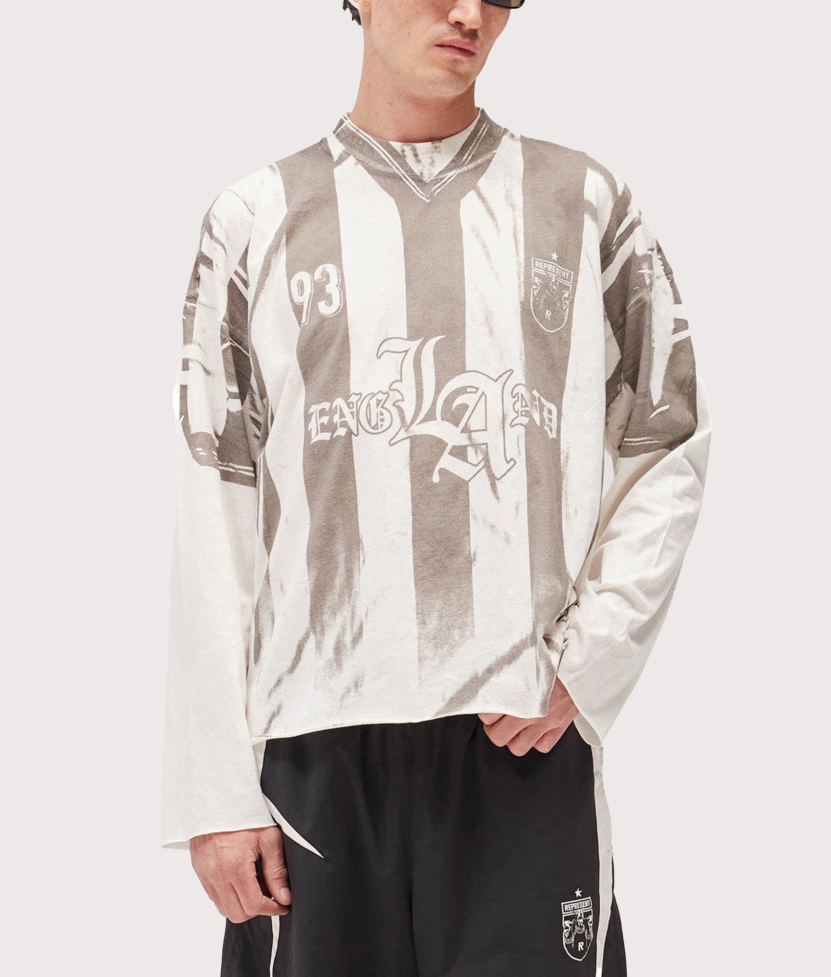 Represent Oversized Fit Printed LS Football Top in Flat White at EQVVS Menswear. Model front shot.