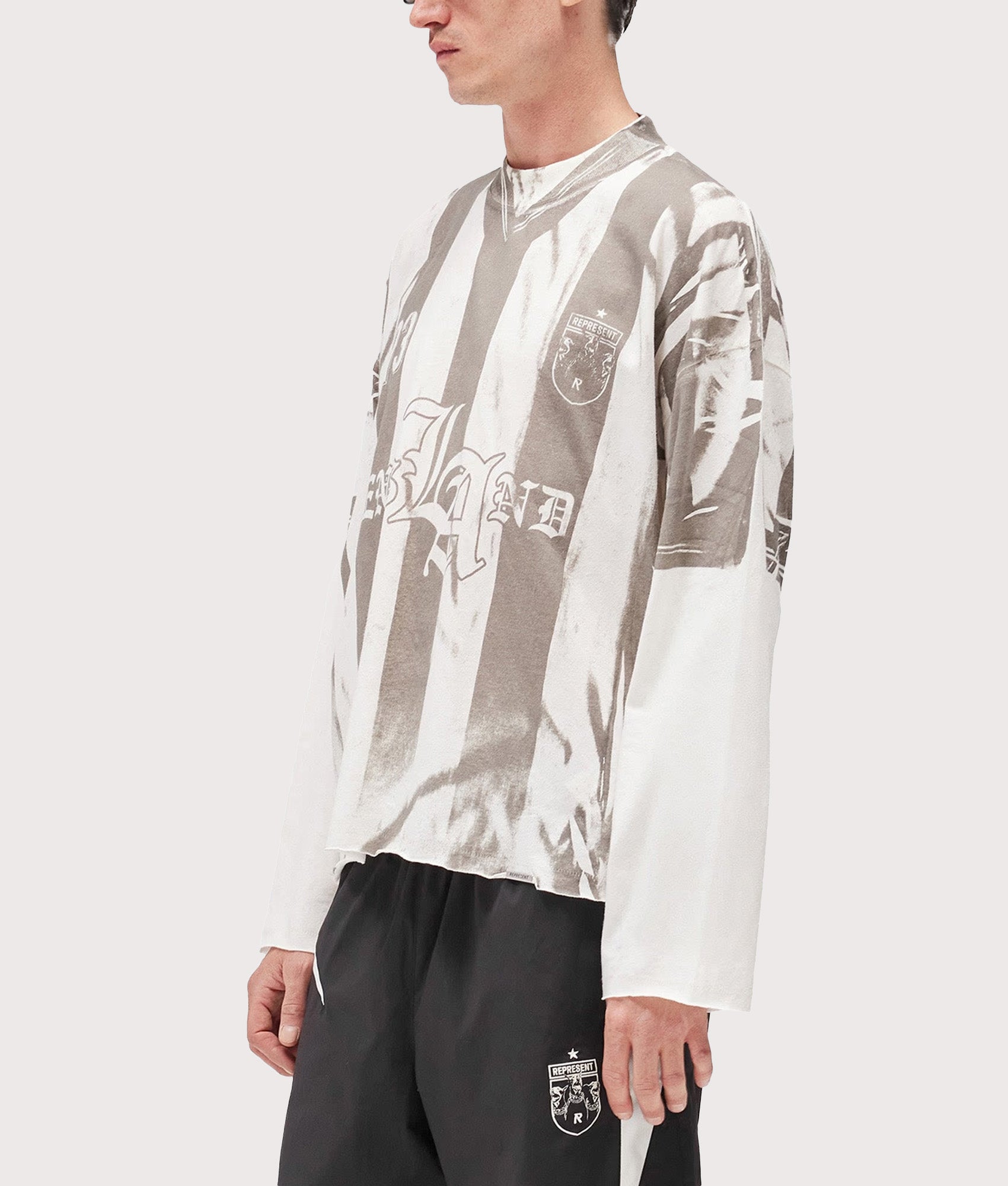 Represent Oversized Fit Printed LS Football Top in Flat White at EQVVS Menswear. Angled model front shot.