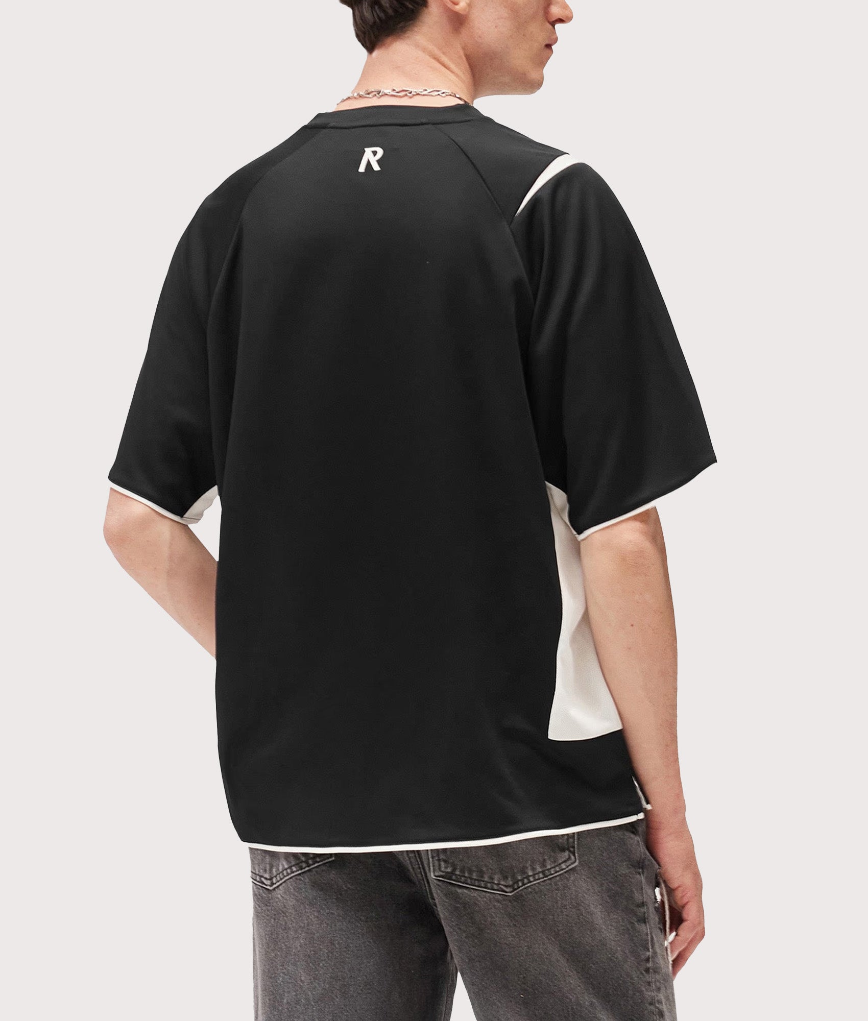Represent Oversized Star Football Top in Jet Black at EQVVS Menswear. Model back shot.