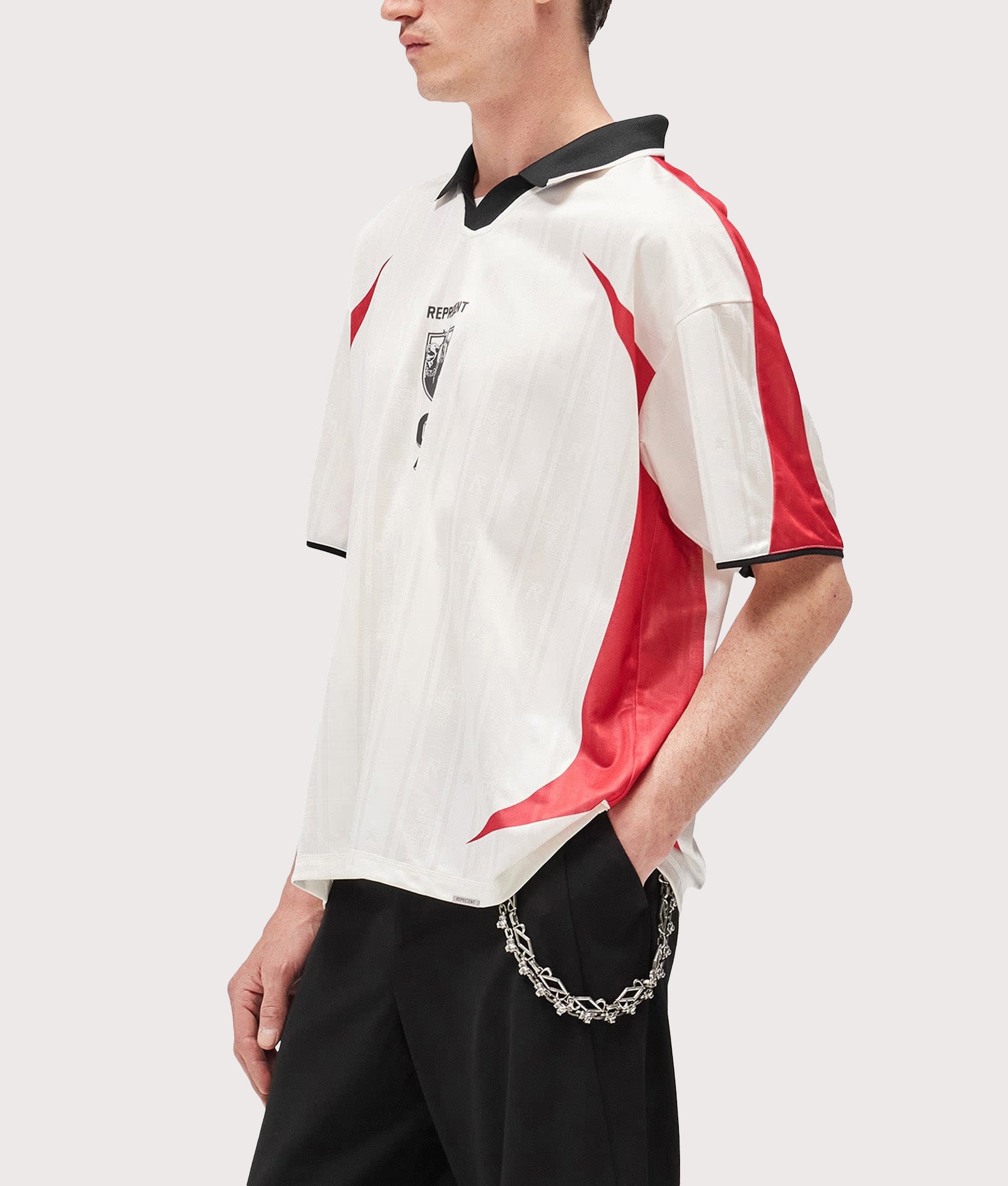 Represent Oversized Fit Spike Football Top in Flat White at EQVVS Menswear.  Model side shot.
