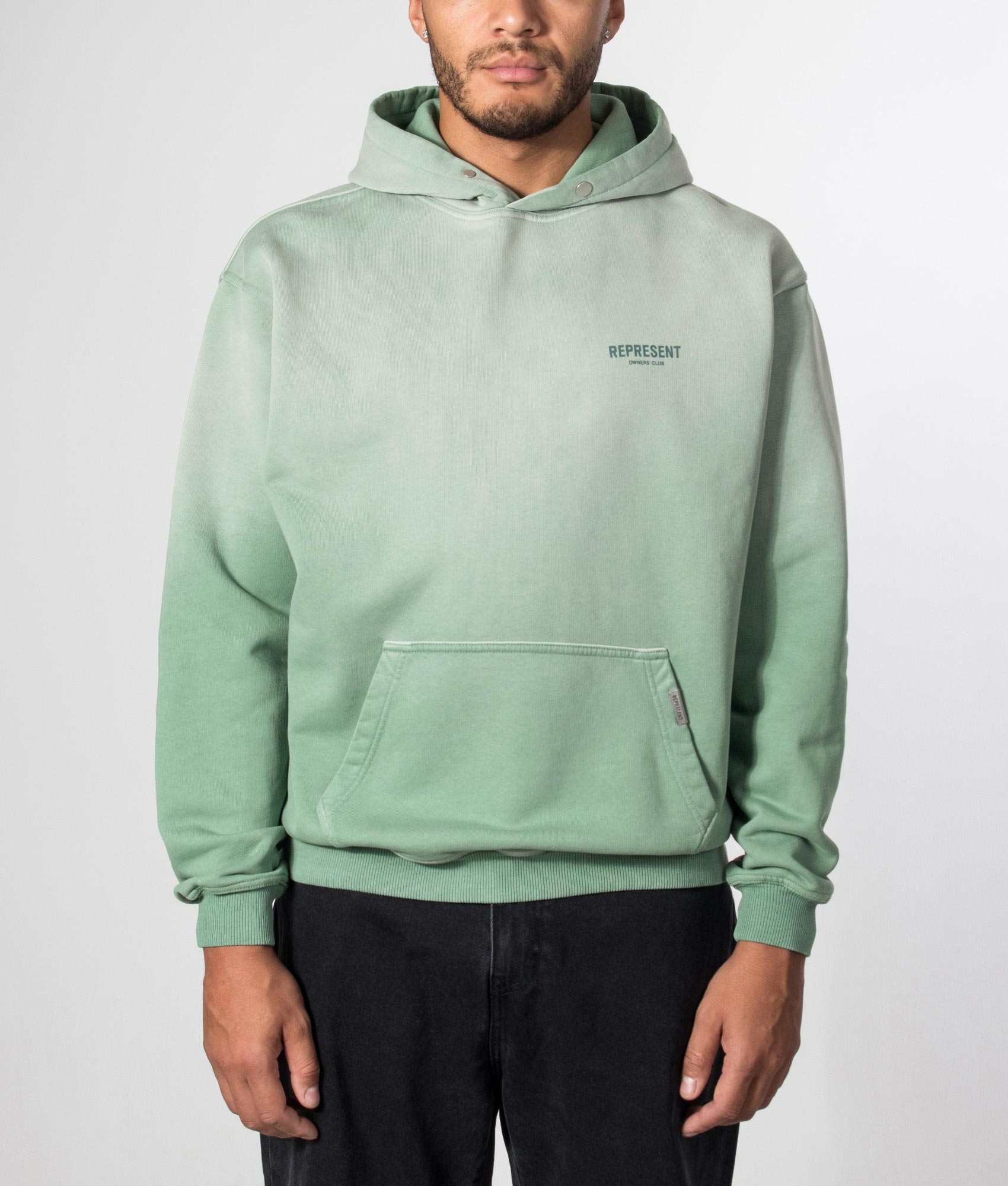 Represent Oversized Fit Represent Owners Club Hoodie in Washed Aloe at EQVVS Menswear. Model front shot.