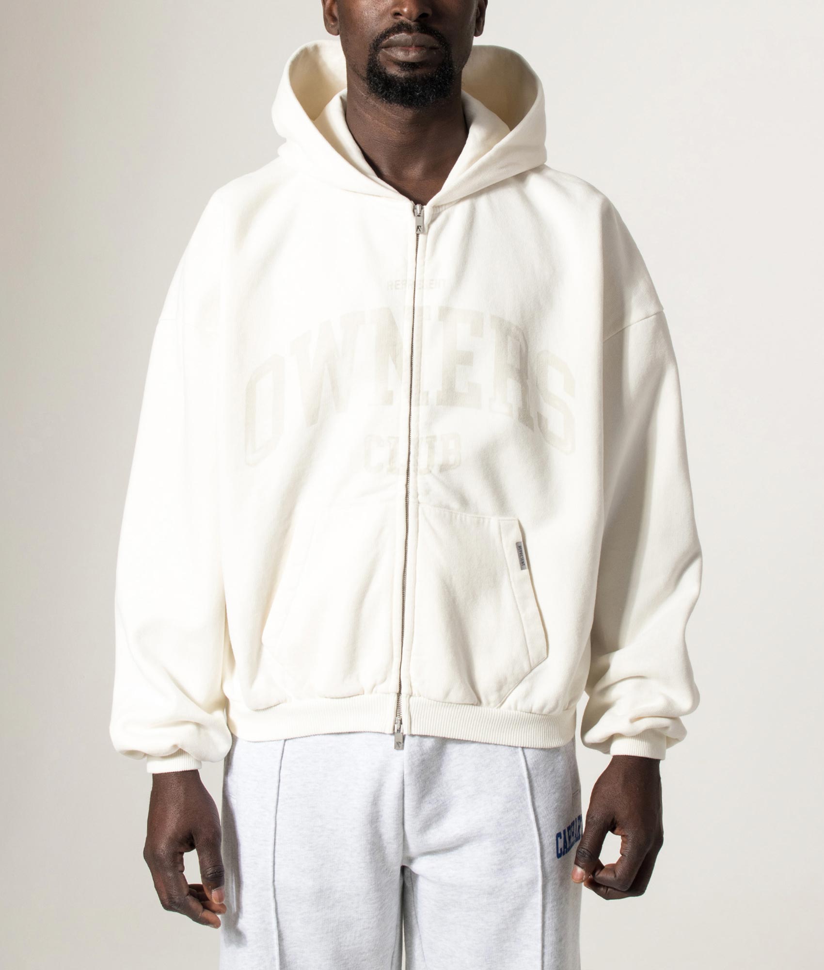 REPRESENT Owners Zip Through Hoodie in Chalk at EQVVS Menswear. Model front shot.