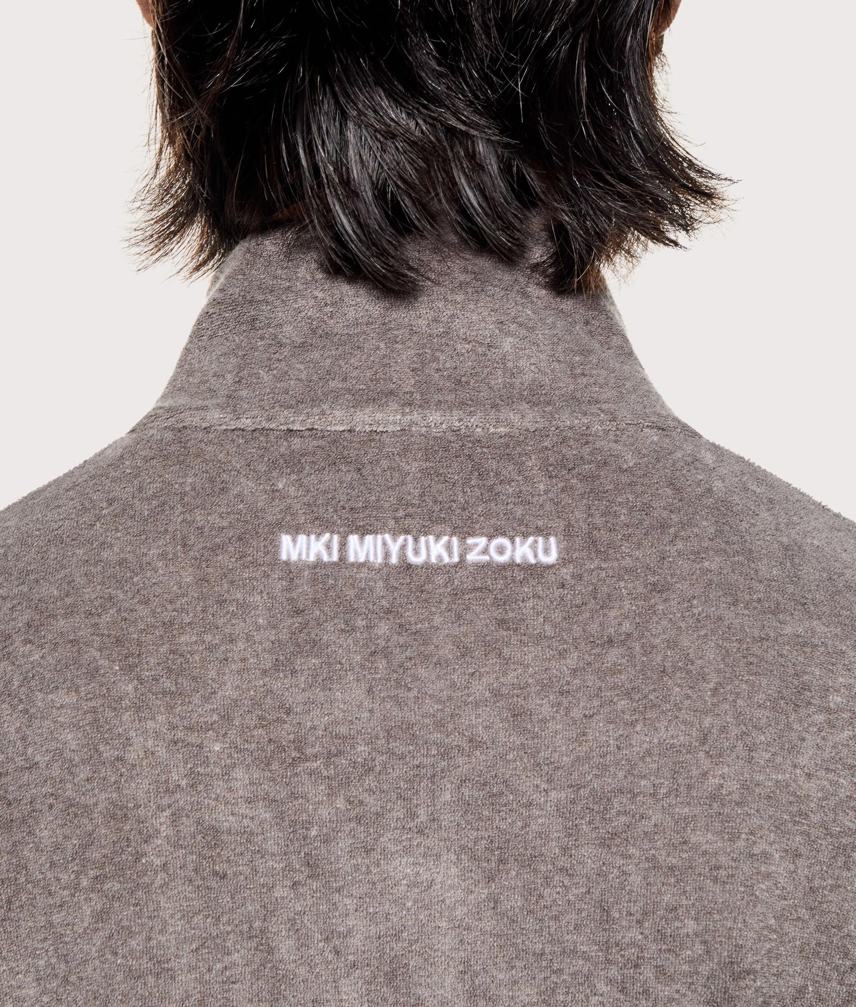MKI MIYUKI ZOKU Towelling Quarter Zip Sweatshirt in Brown at EQVVS Menswear. Detail shot.