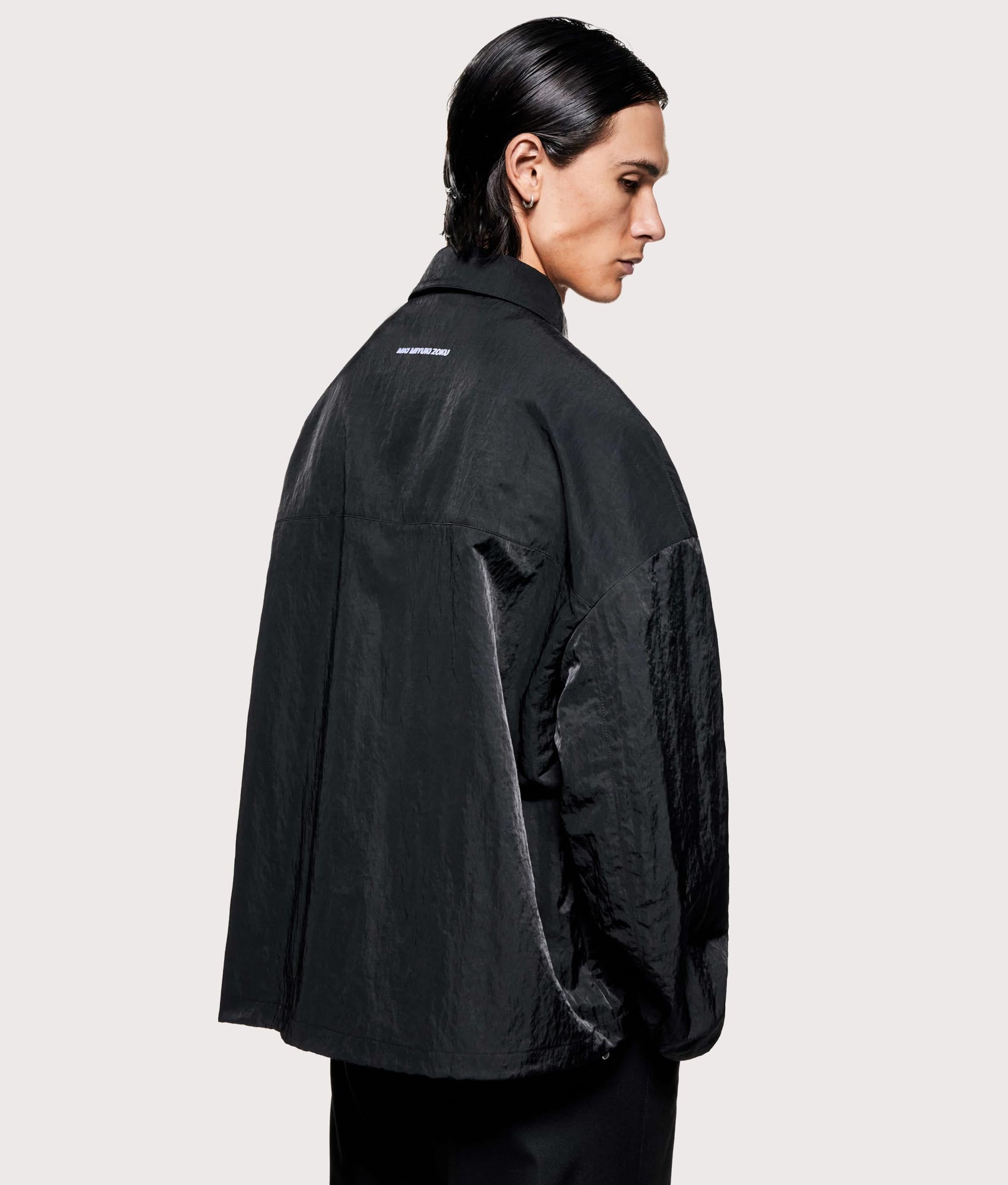 MKI MIYUKI ZOKU Silky nylon box overshirt in black at EQVVS Menswear. Angled model back shot.