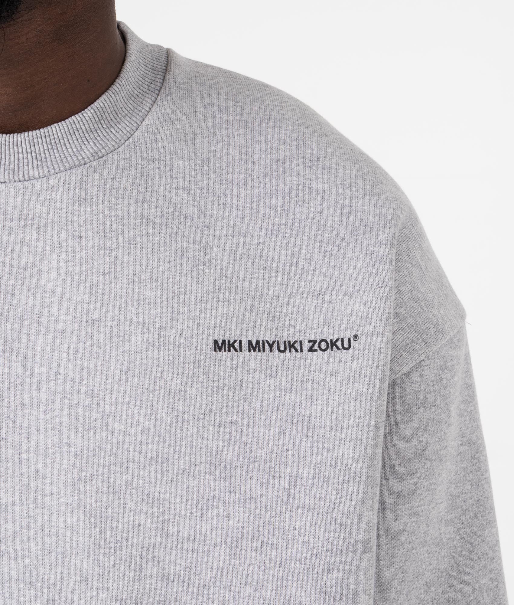MKI MIYUKI ZOKU Oversized Uniform Crewneck Sweatshirt in grey at EQVVS Menswear.  Model detail shot.