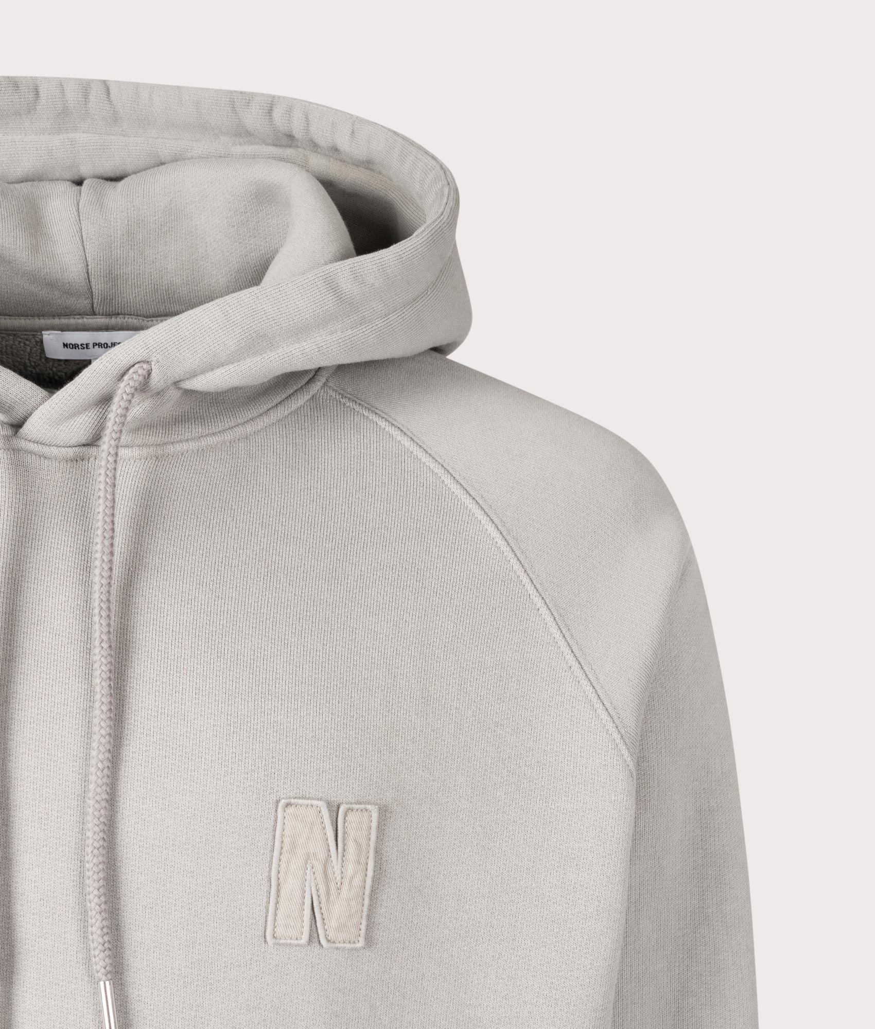 Norse Projects Relaxed Fit Marten Raglan N Patch Hoodie in Weather Grey at EQVVS Menswear Detail Shot