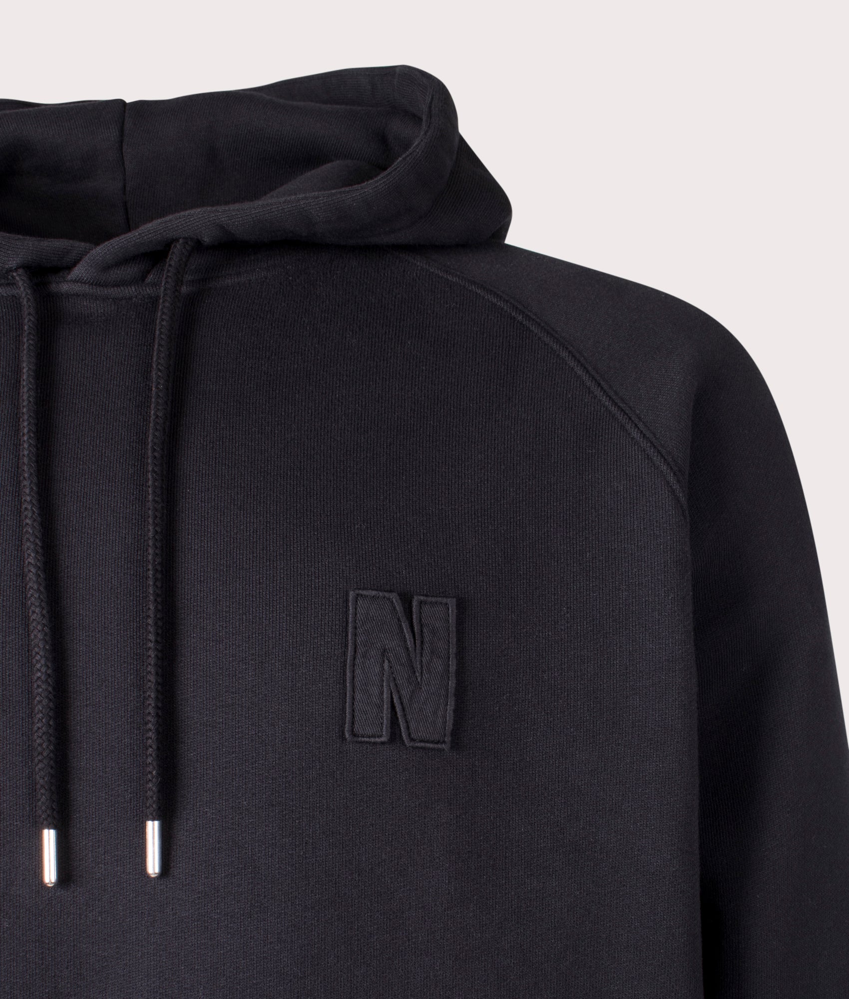 Norse Projects Relaxed Fit Marten Raglan N Patch Hoodie in Black at EQVVS Menswear Detail Shot