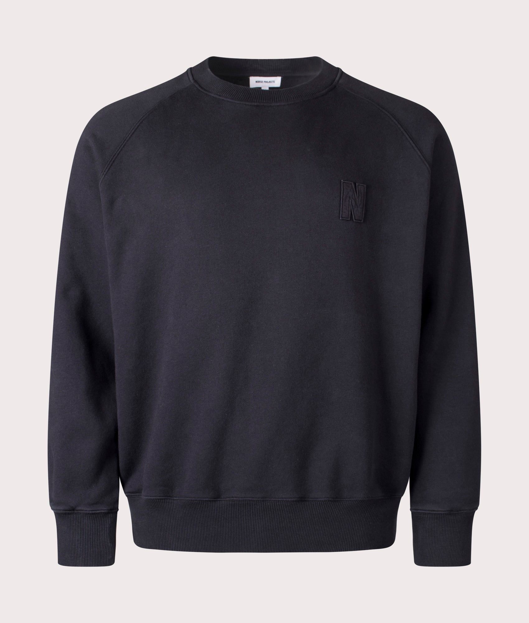 Norse Projects Relaxed Fit Marten Raglan N Patch Sweatshirt in Black Organic Cotton at EQVVS Menswear Front Shot