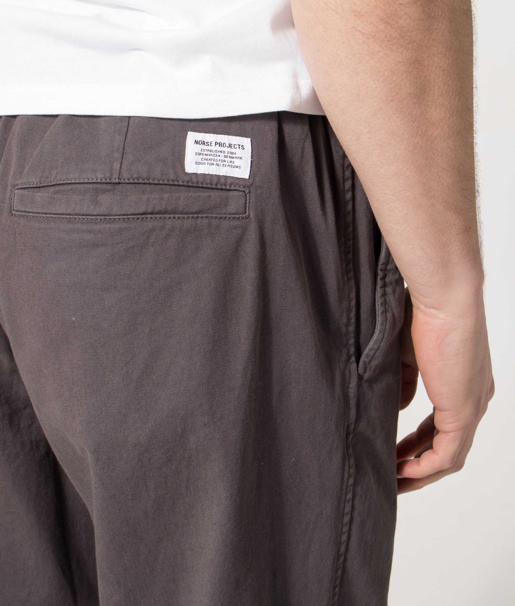 Norse Projects Relaxed Fit Ezra Organic Stretch Twill Trousers in Graphite at EQVVS Menswear. Model back shot.
