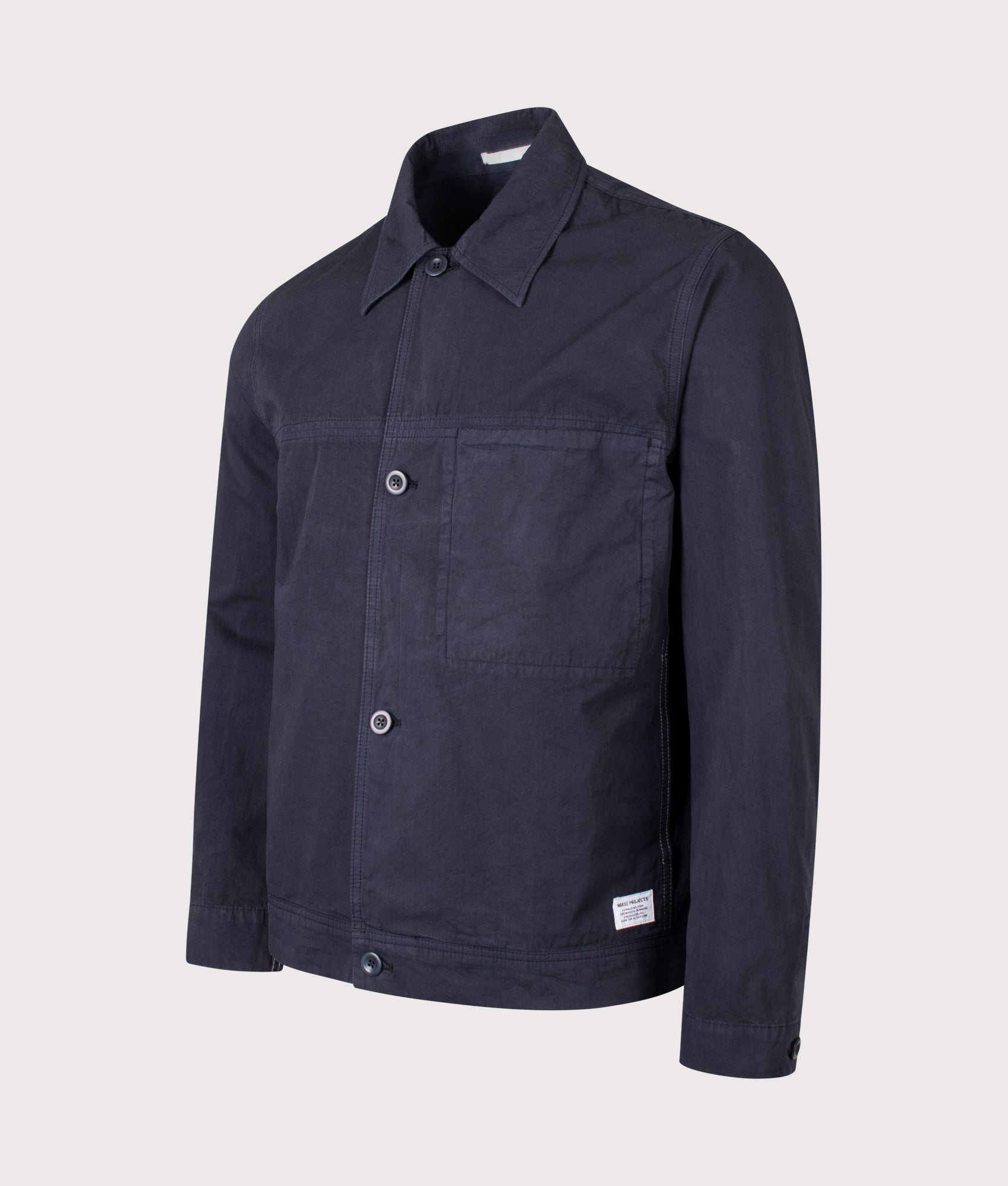 Norse Projects Relaxed Fit Arresskov Compact Cotton Overshirt in Dark Navy at EQVVS Menswear. Angled front shot.