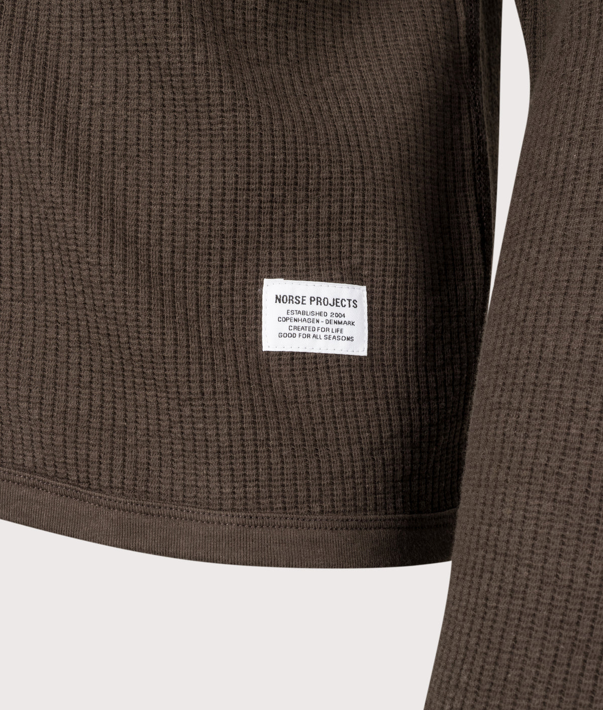 Norse Projects Relaxed Fit Military Rib Zip Through Cardigan in Delicioso Brown at EQVVS Menswear. Detail shot.