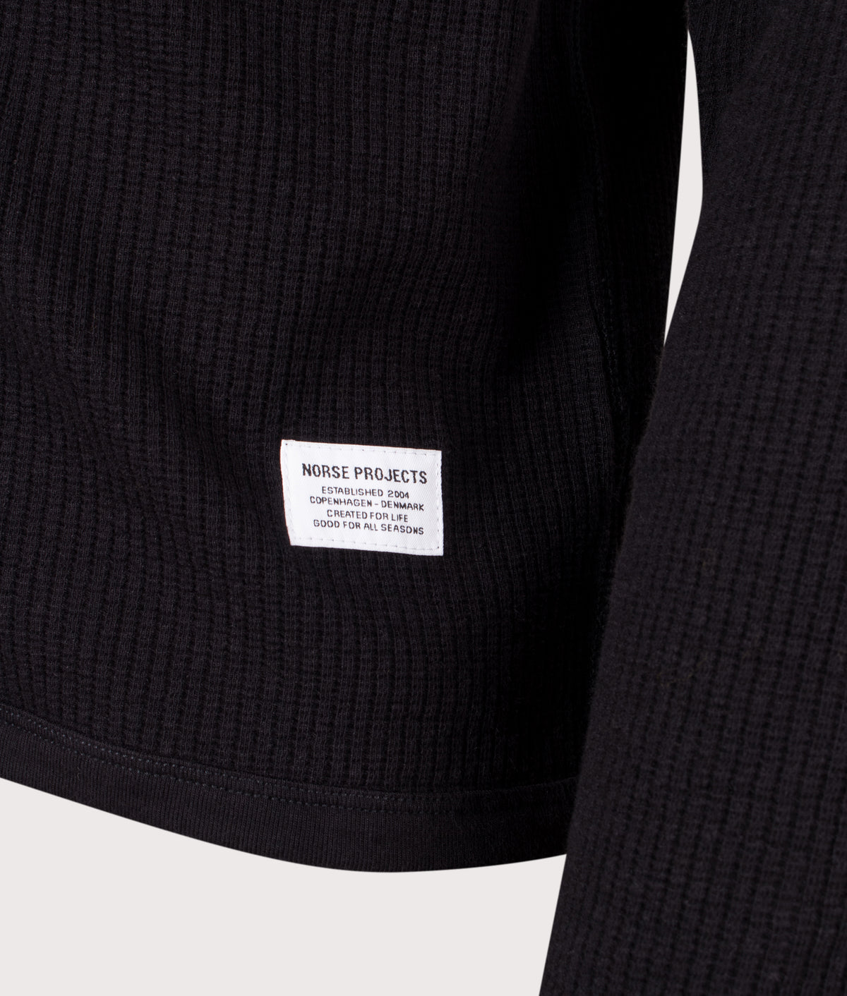 Norse Projects Relaxed Fit Military Rib Zip Through Cardigan in Black at EQVVS Menswear. Detail shot.