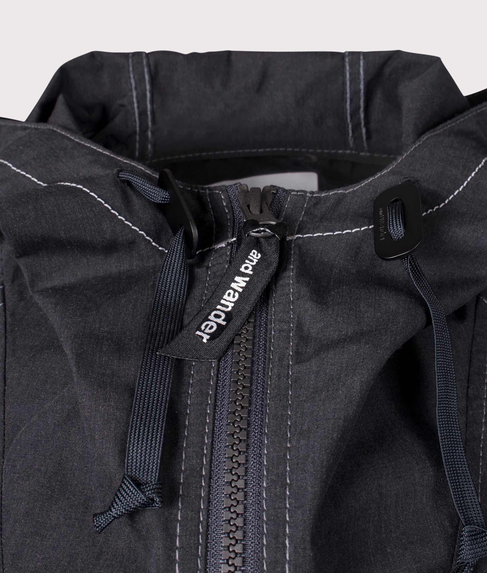 and wander Tough Aramid Hoodie in Charcoal at EQVVS. Zip Detail Shot.