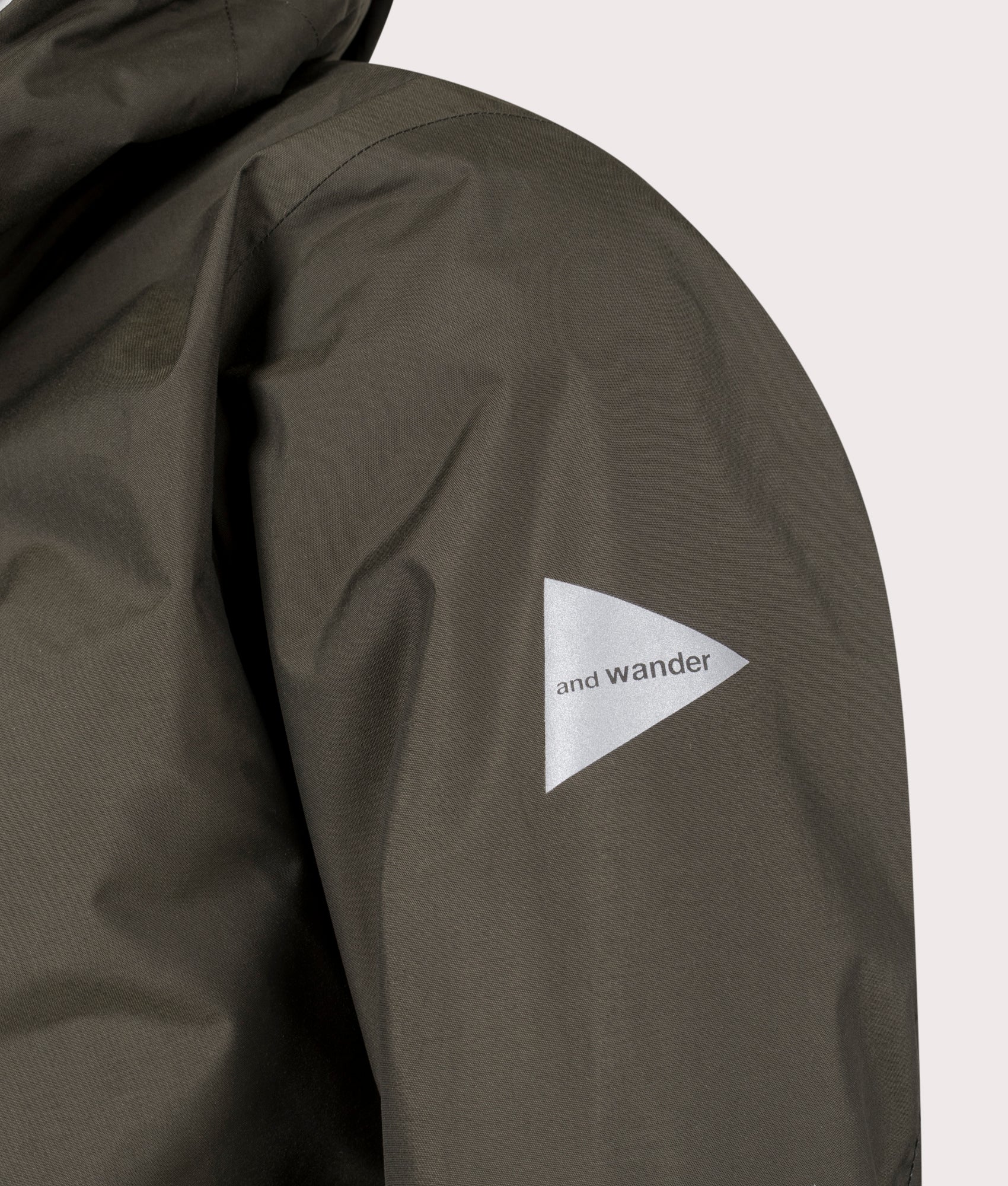 and wander 2.5L Hiker Rain Jacket in Dark Khaki. Shot at EQVVS. Arm logo shot 