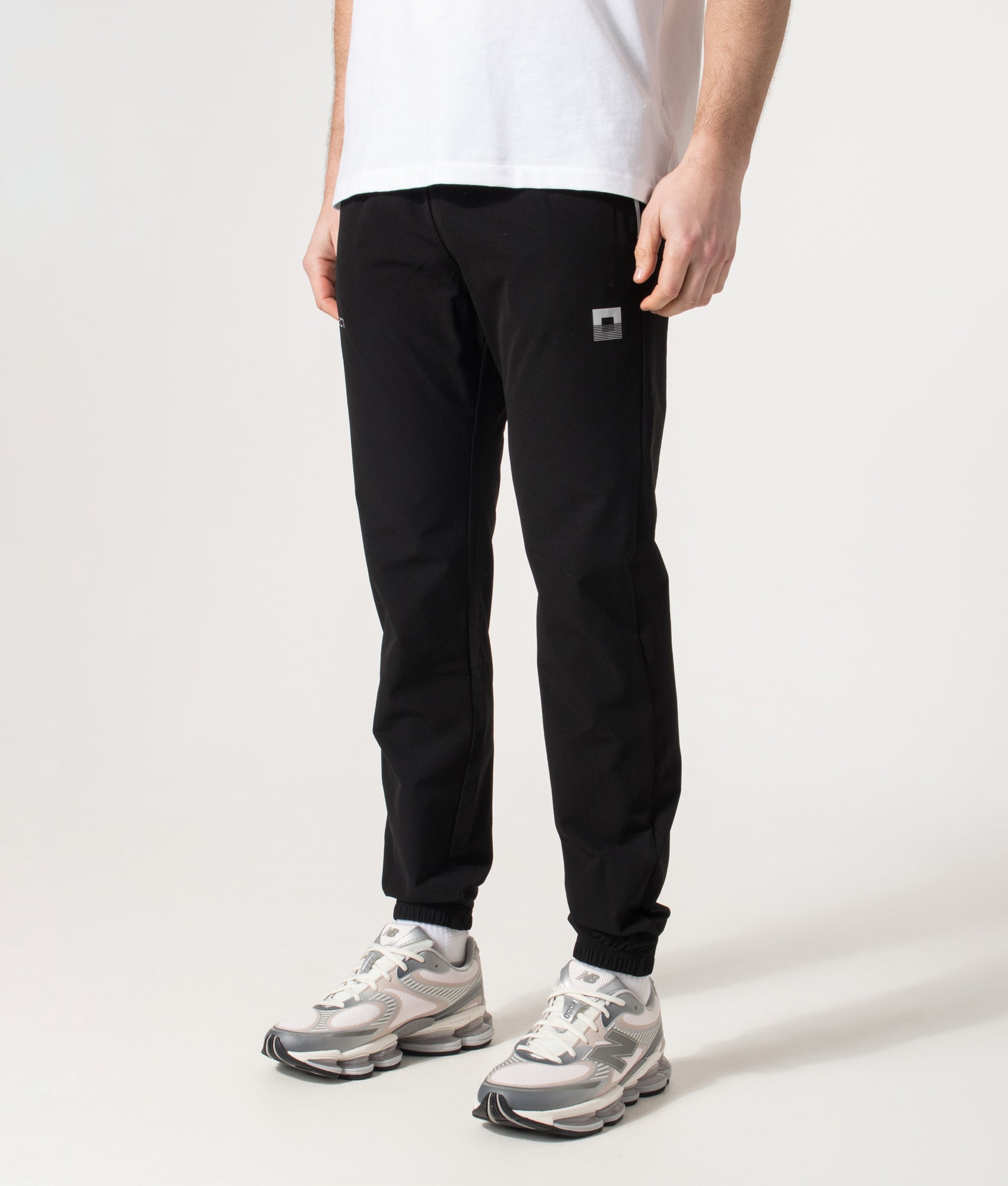 REFLECT Woven Track Pants in Black at EQVVS Menswear. Angled model front shot.