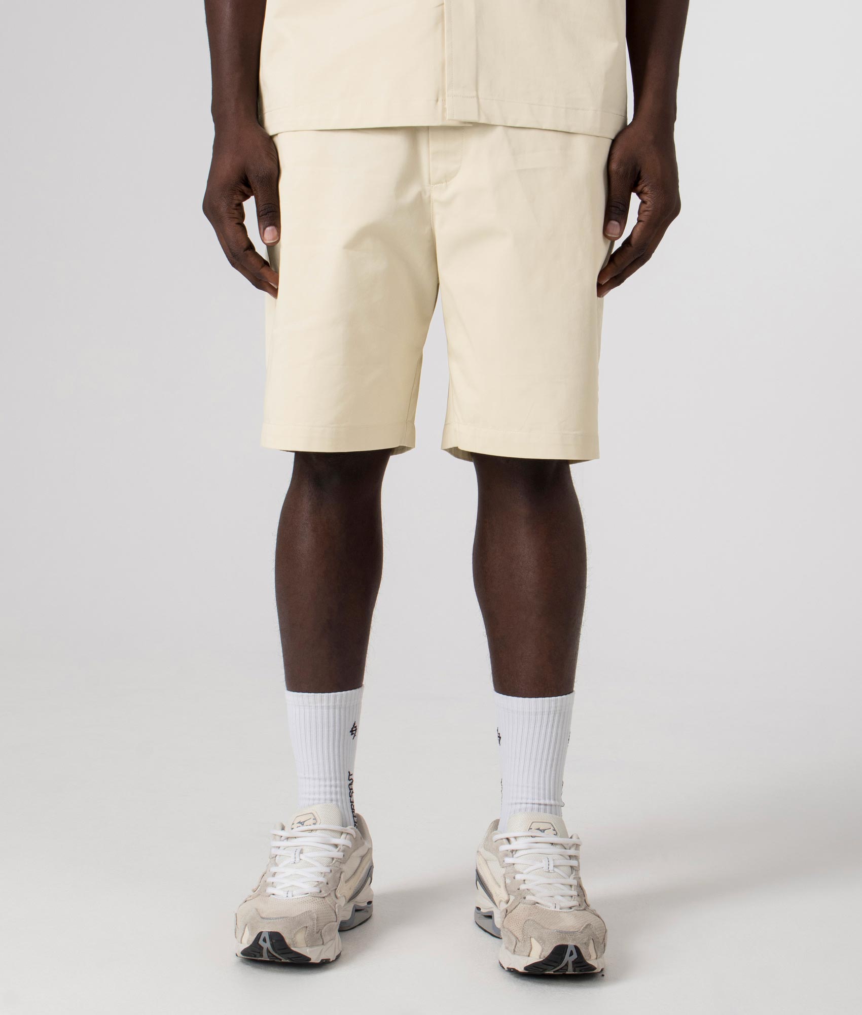 Axel Arigato Stitch Embroidered Shorts in Pale Beige. Shot at EQVVS. Front shot. 