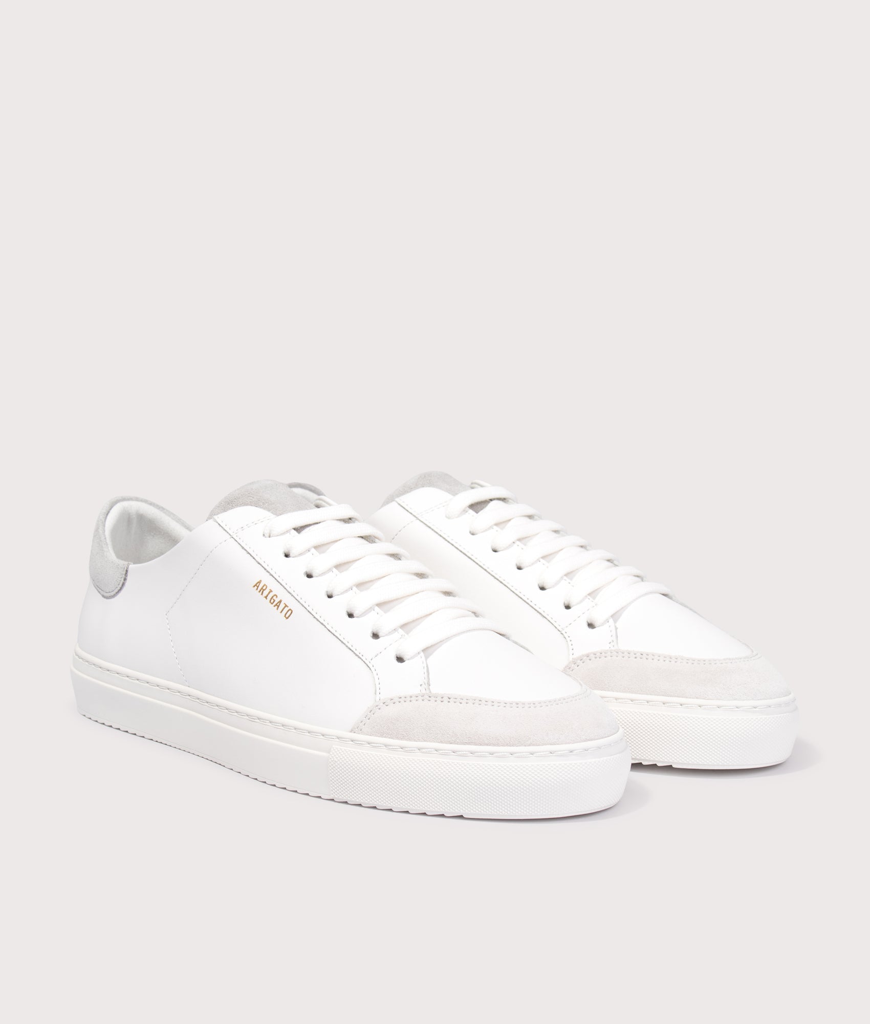 Axel Arigato Clean 90 Triple Sneakers in White/Grey at EQVVS Menswear. Angled front shot.